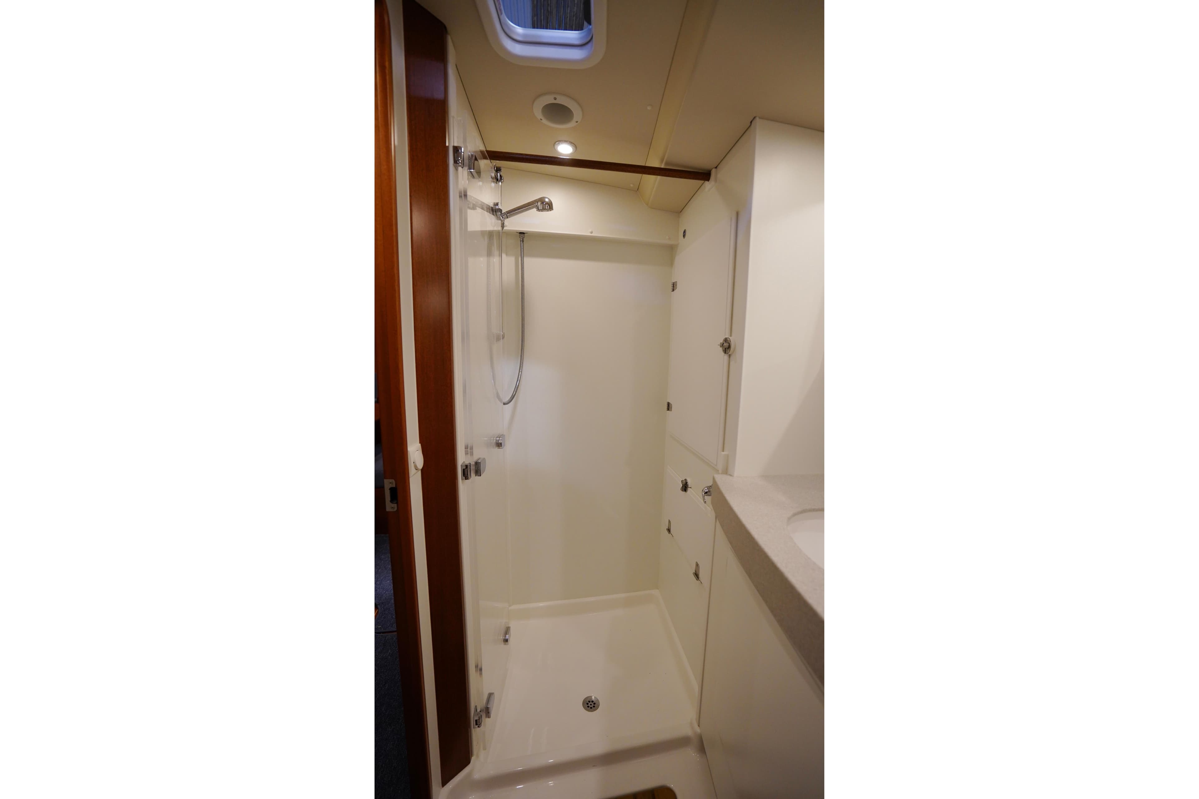 2020 Hallberg-Rassy 57 yacht bathroom with modern shower and sleek cabinetry.
