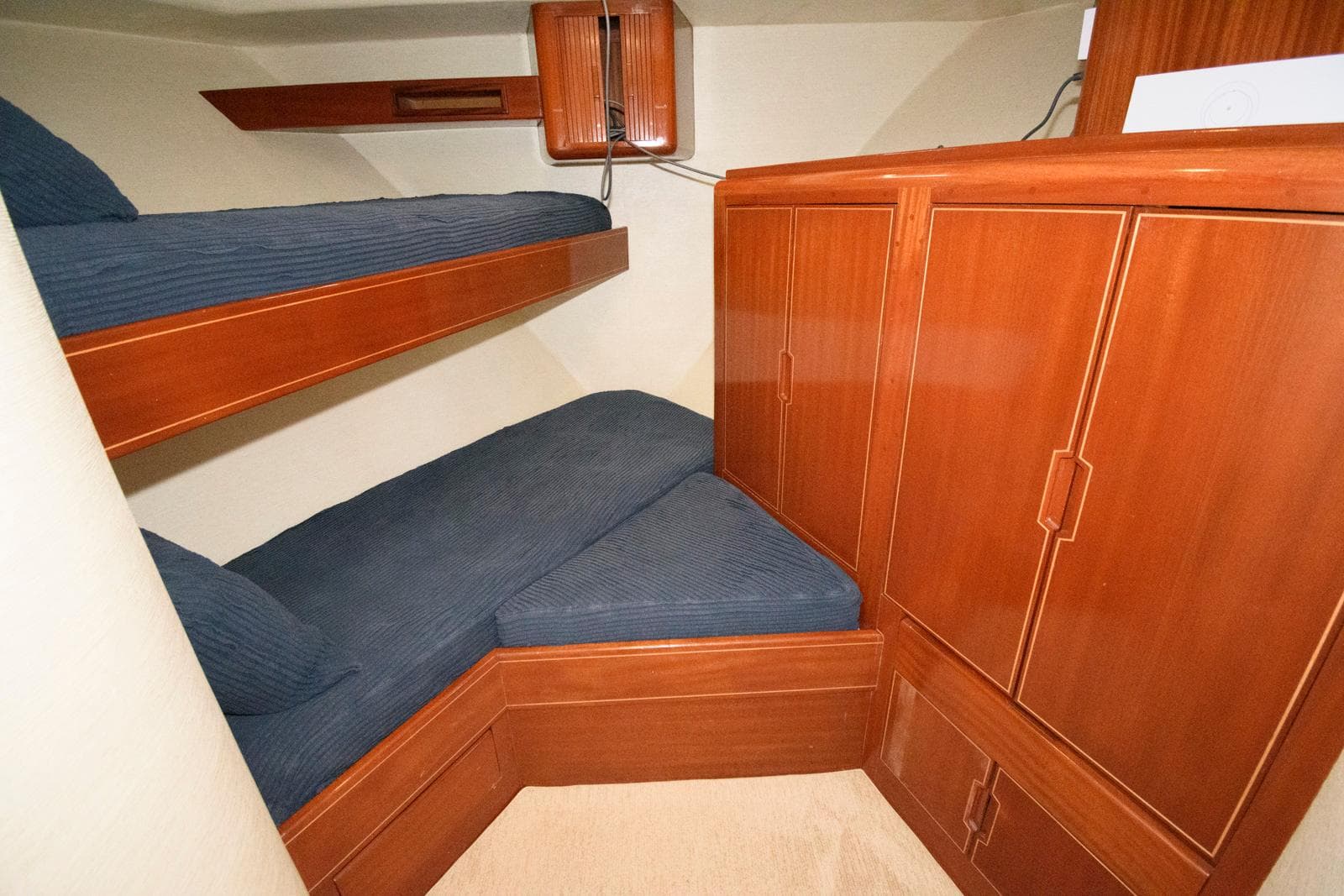 1998 Huckins 70 Sportfish Convertible cabin with wooden bunk beds and storage cabinets.