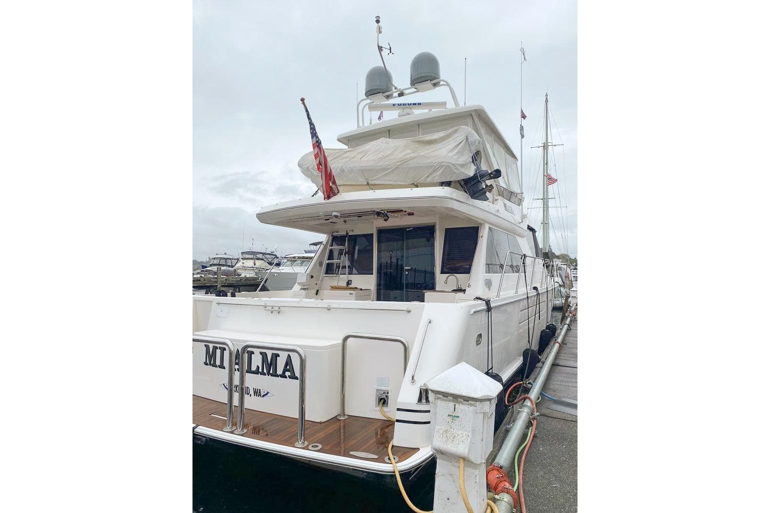 2004 West Bay Sonship yacht docked at marina, rear view with American flag.