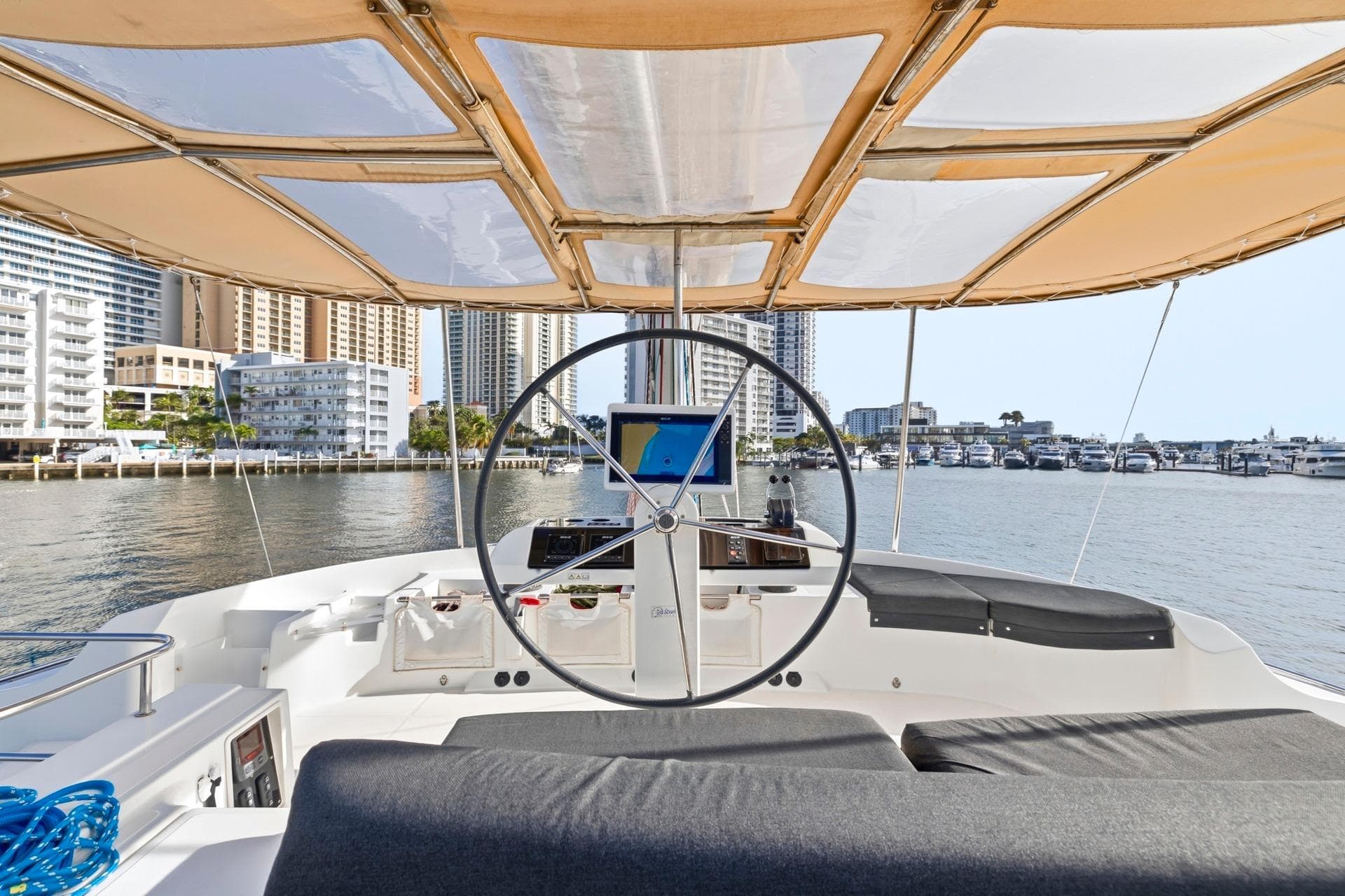 Helm of 2021 Lagoon 52 F yacht with city skyline in background.