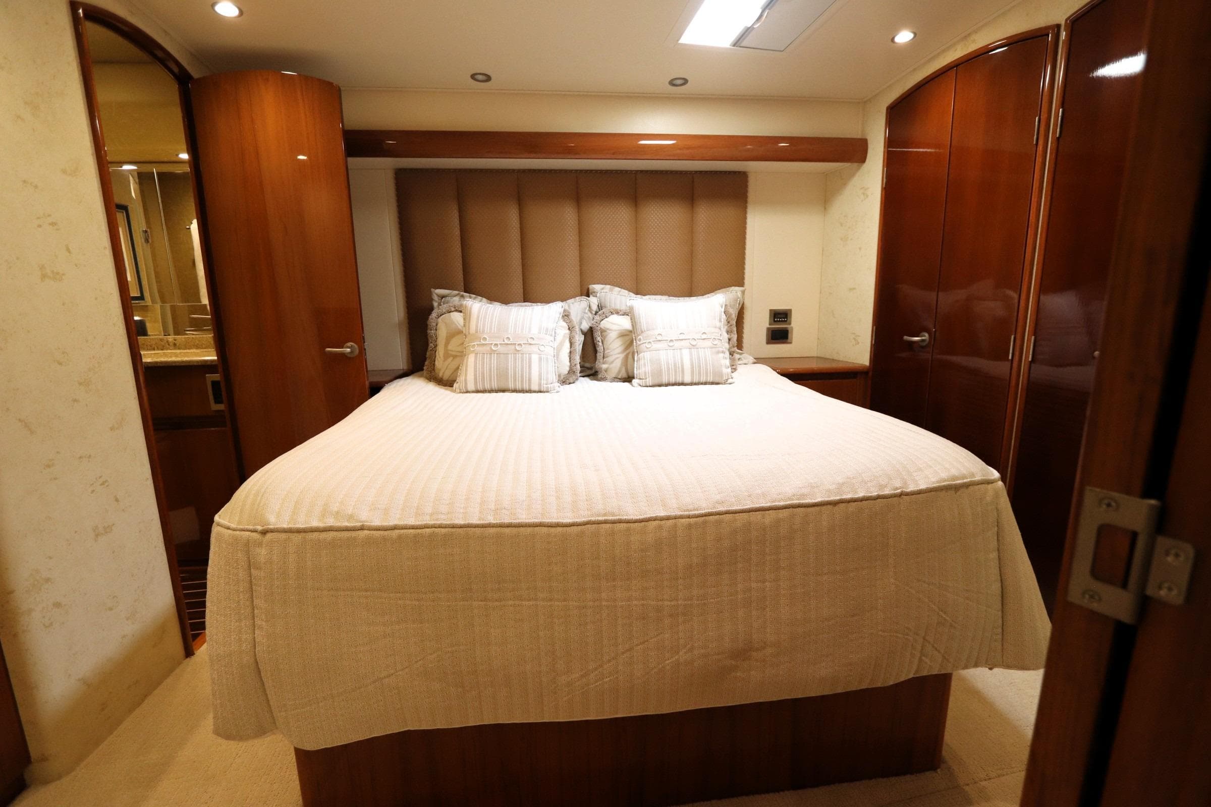Luxurious bedroom interior of 2013 Viking 66 yacht with elegant wood finishes.