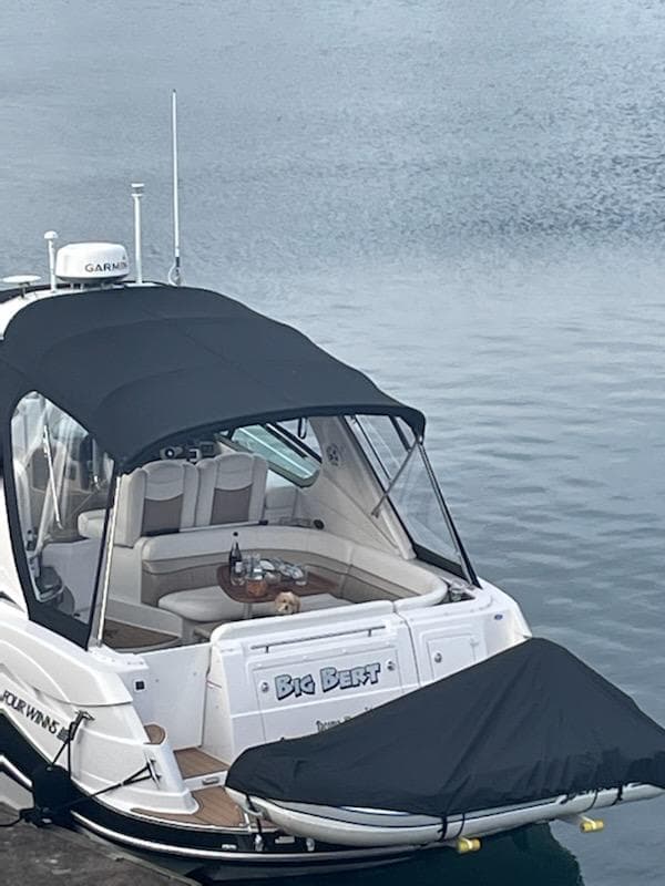 2006 Four Winns 350 boat docked, featuring a covered seating area and sleek design.