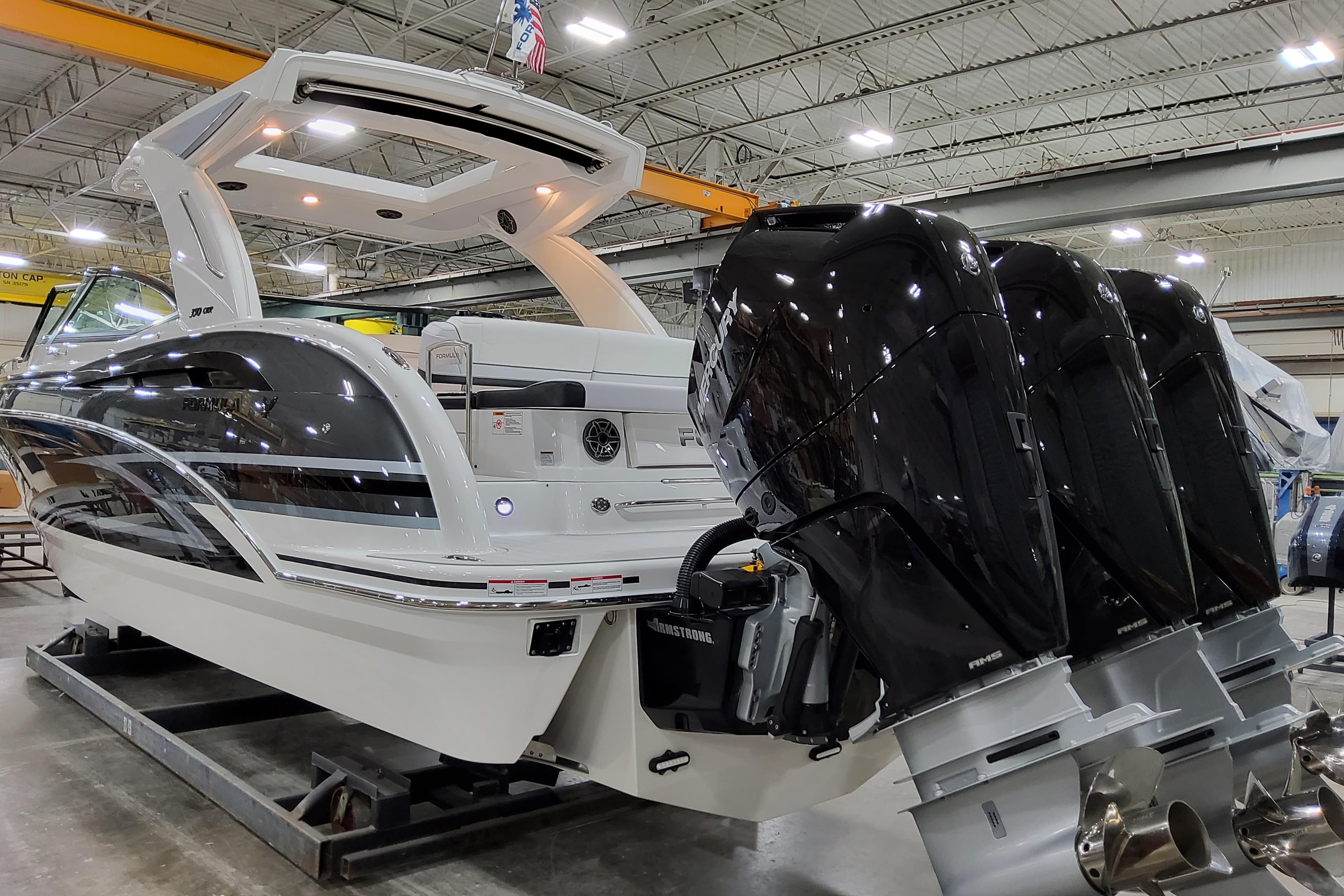 2026 Formula 350 Crossover Bowrider OB with triple outboard engines in a showroom.