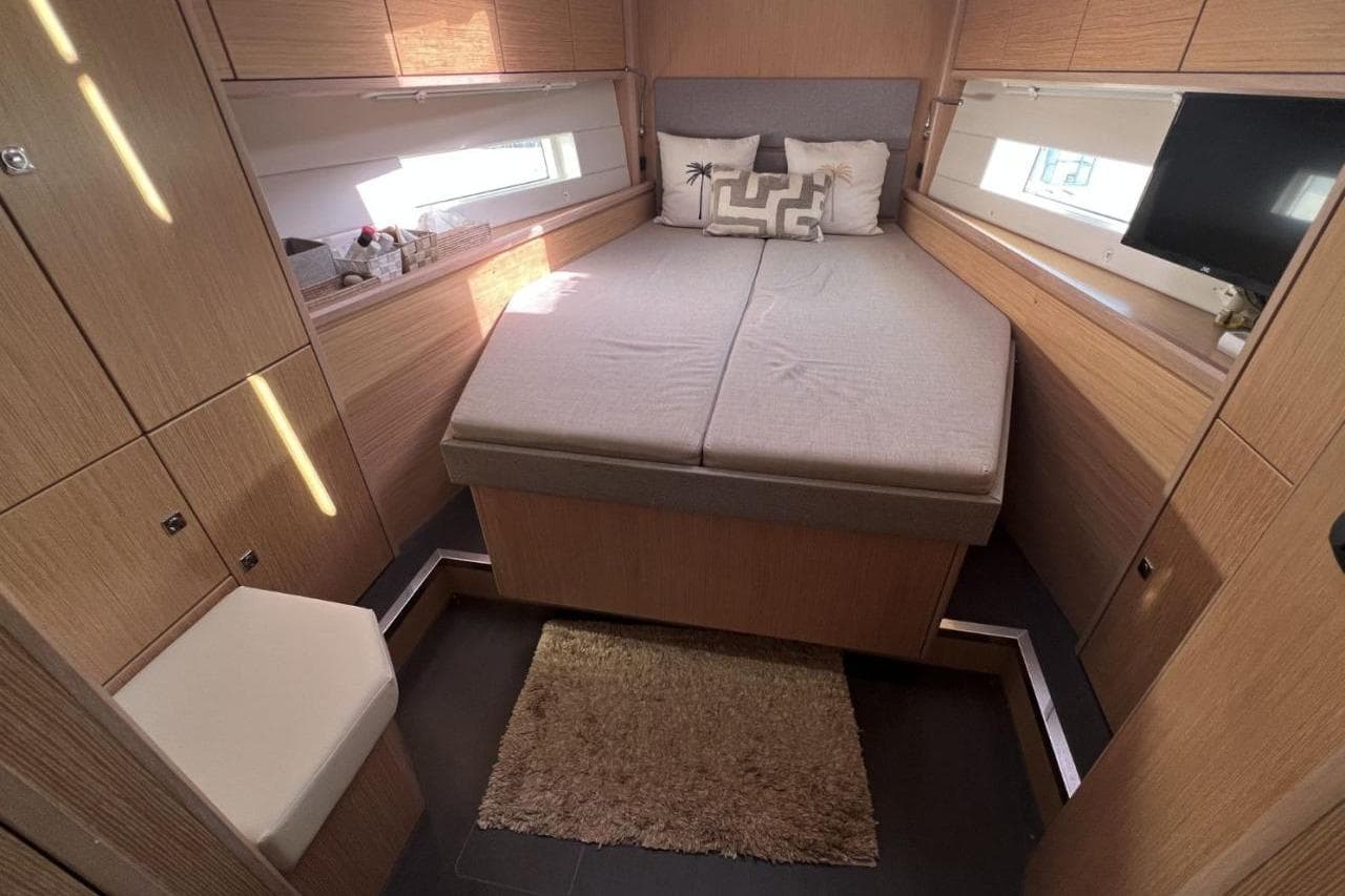 Luxurious interior cabin of 2019 Bavaria 45 Cruiser yacht with cozy bed and wooden finish.