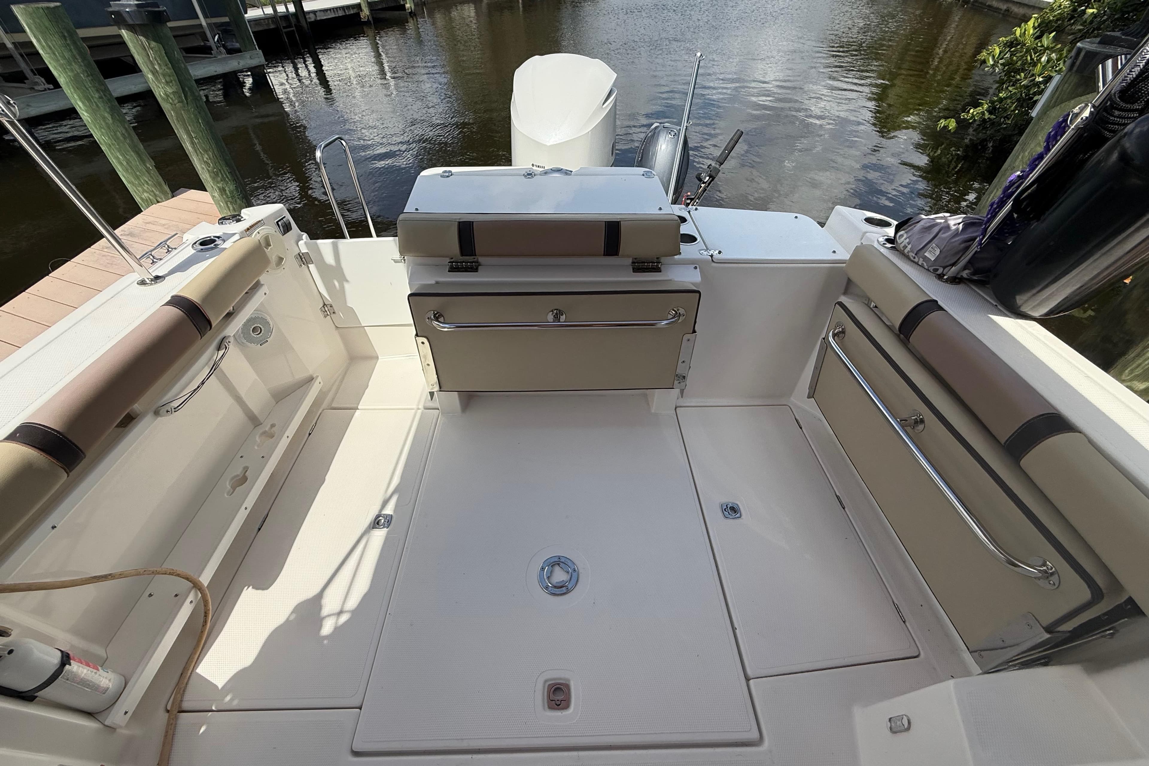 2019 Ranger Tugs R-27 boat deck with seating and storage, docked by water.