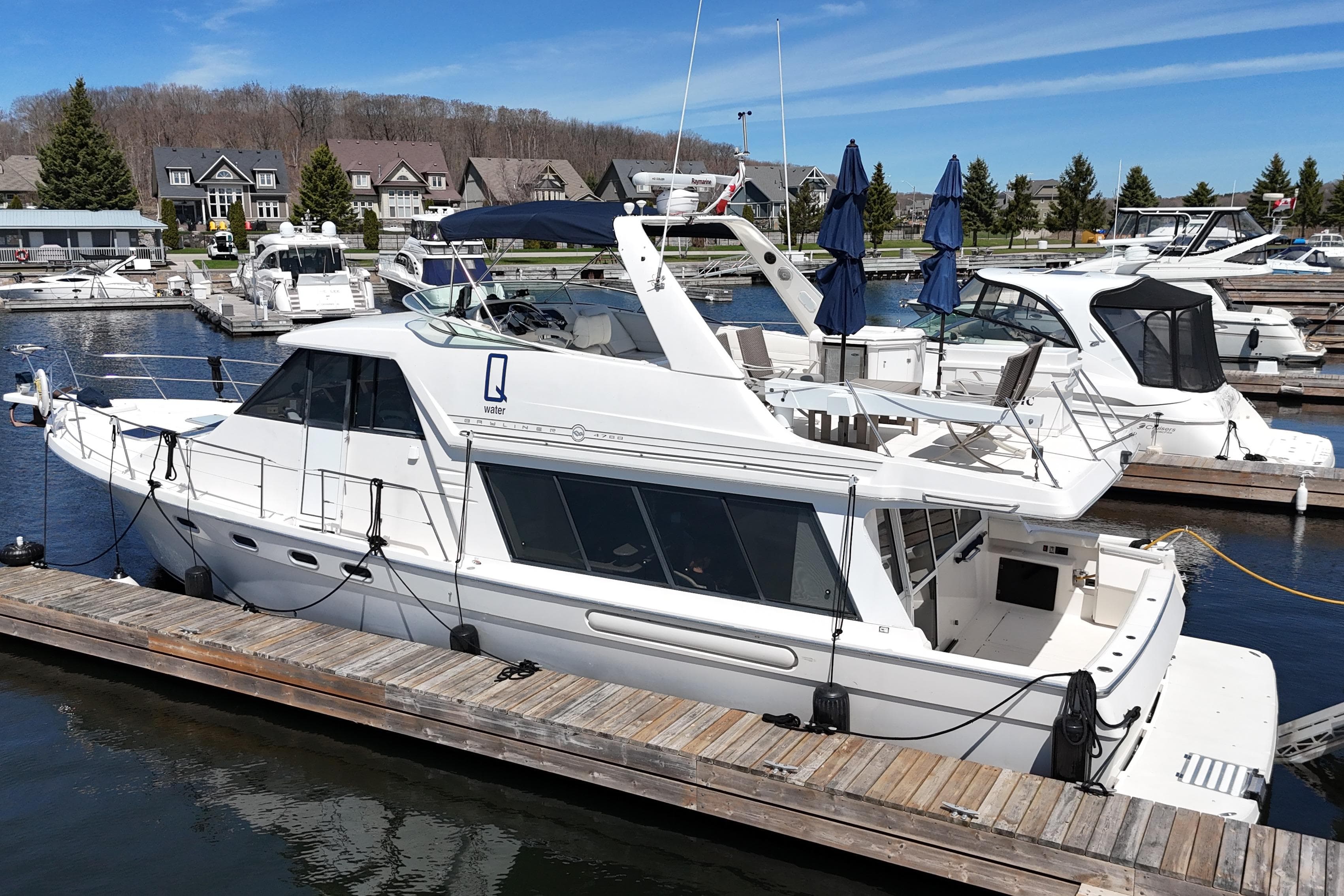1997 Bayliner 4788 Pilot House Motoryacht docked at a marina under clear blue skies.
