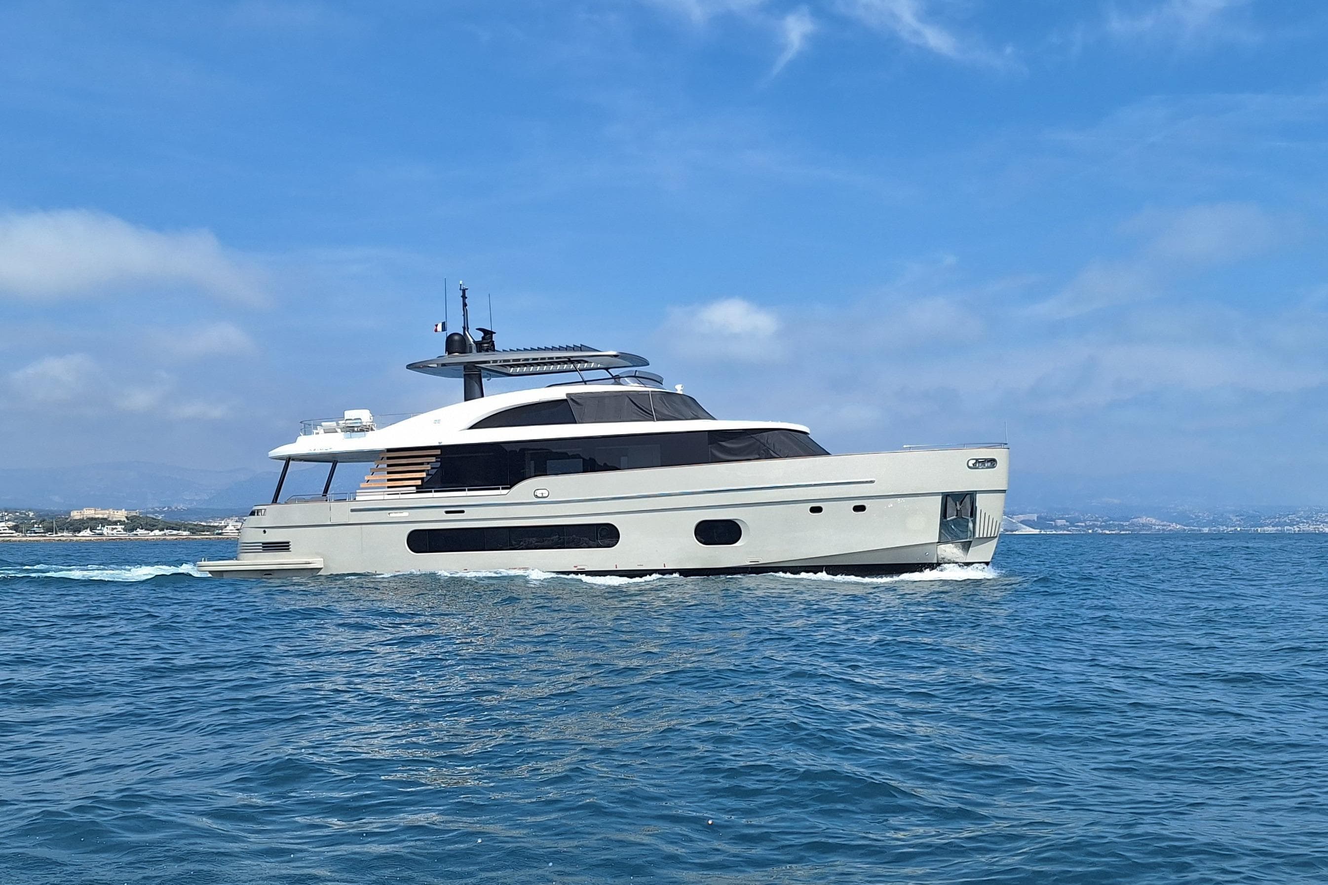 Luxury yacht Azimut Magellano 25M 2022 cruising on open sea under clear blue sky.