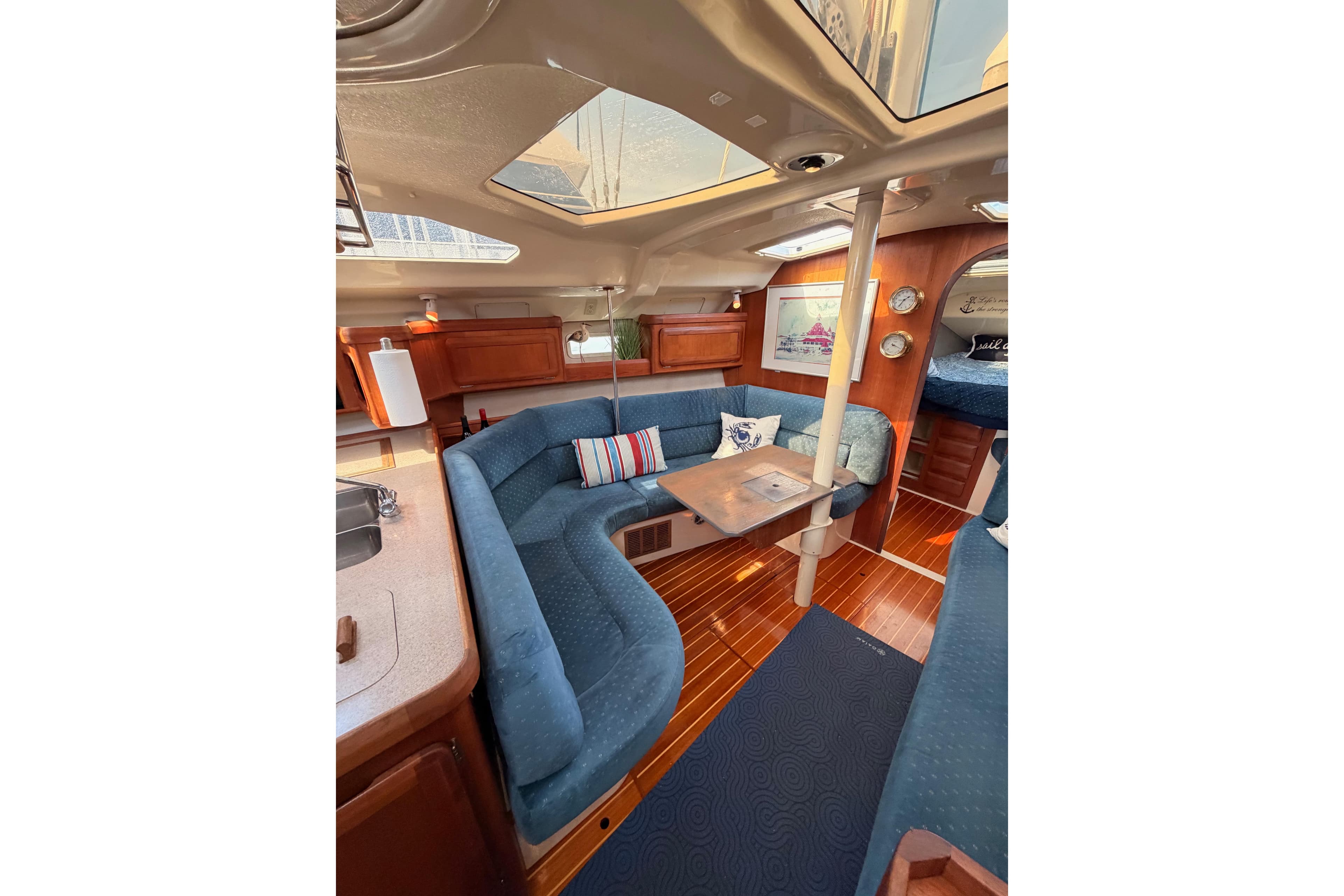 Interior of 1998 Hunter Legend 40.5 yacht with blue seating and wooden accents.