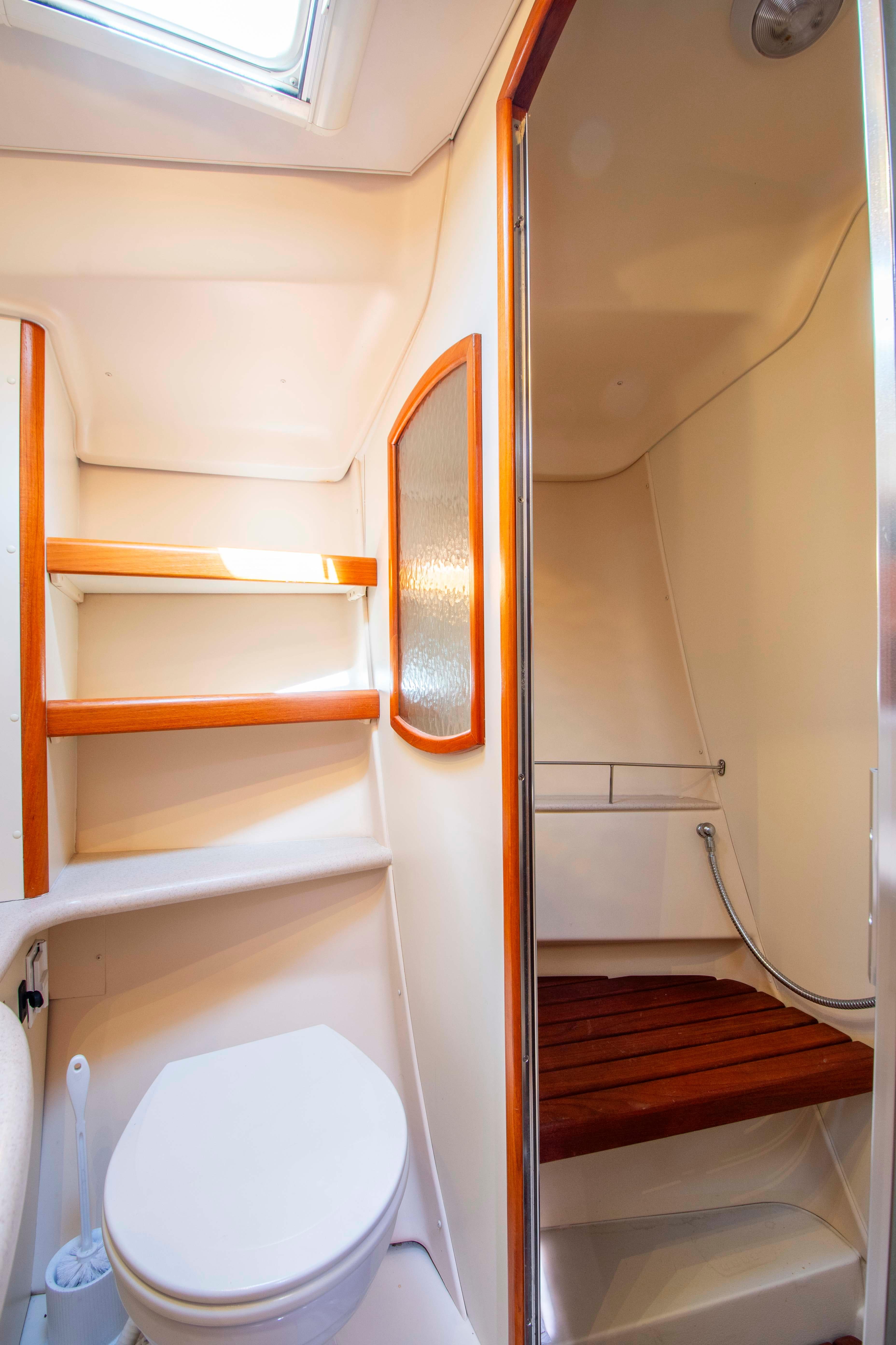 2005 Hunter 45 CC yacht bathroom with shower, toilet, and wooden accents.