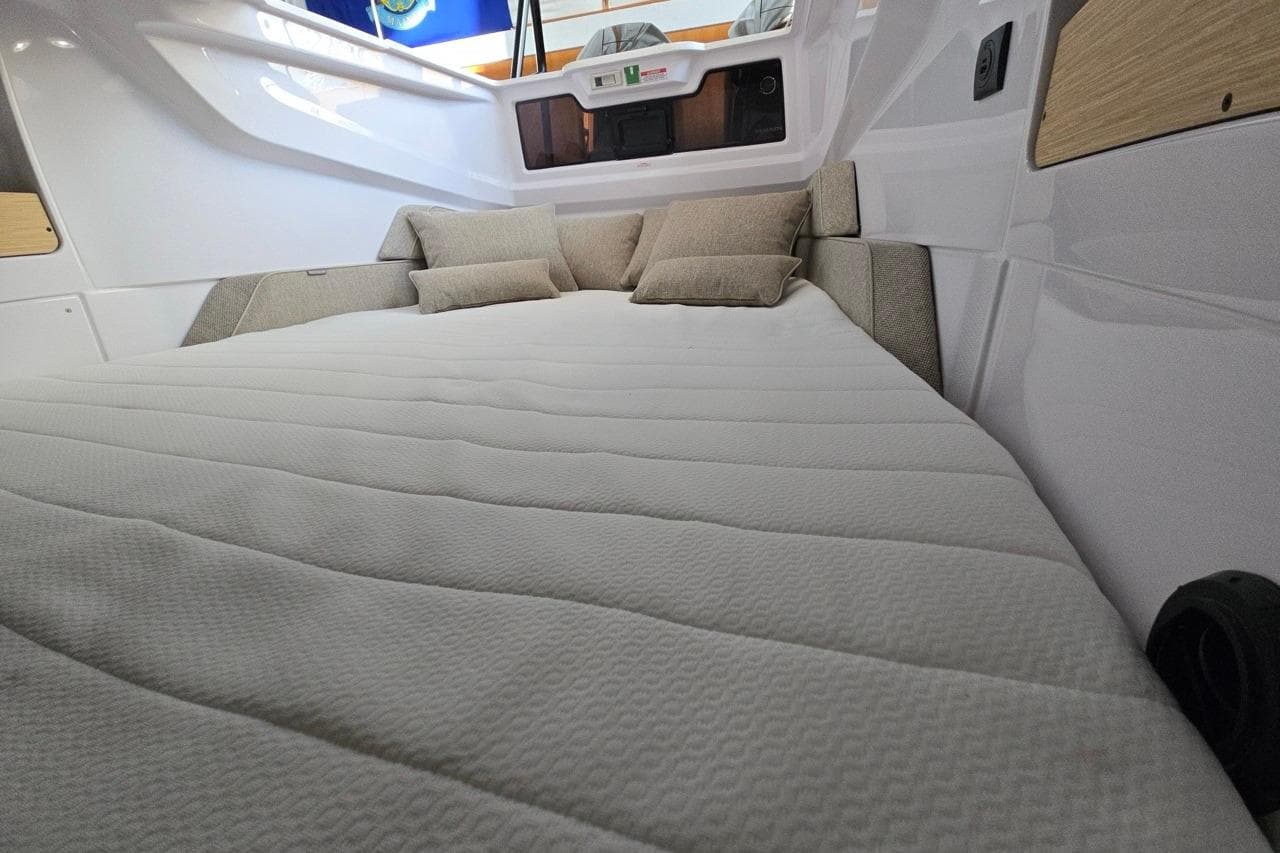2026 Axopar 29 XC Cross Cabin interior with cozy bed and cushions.