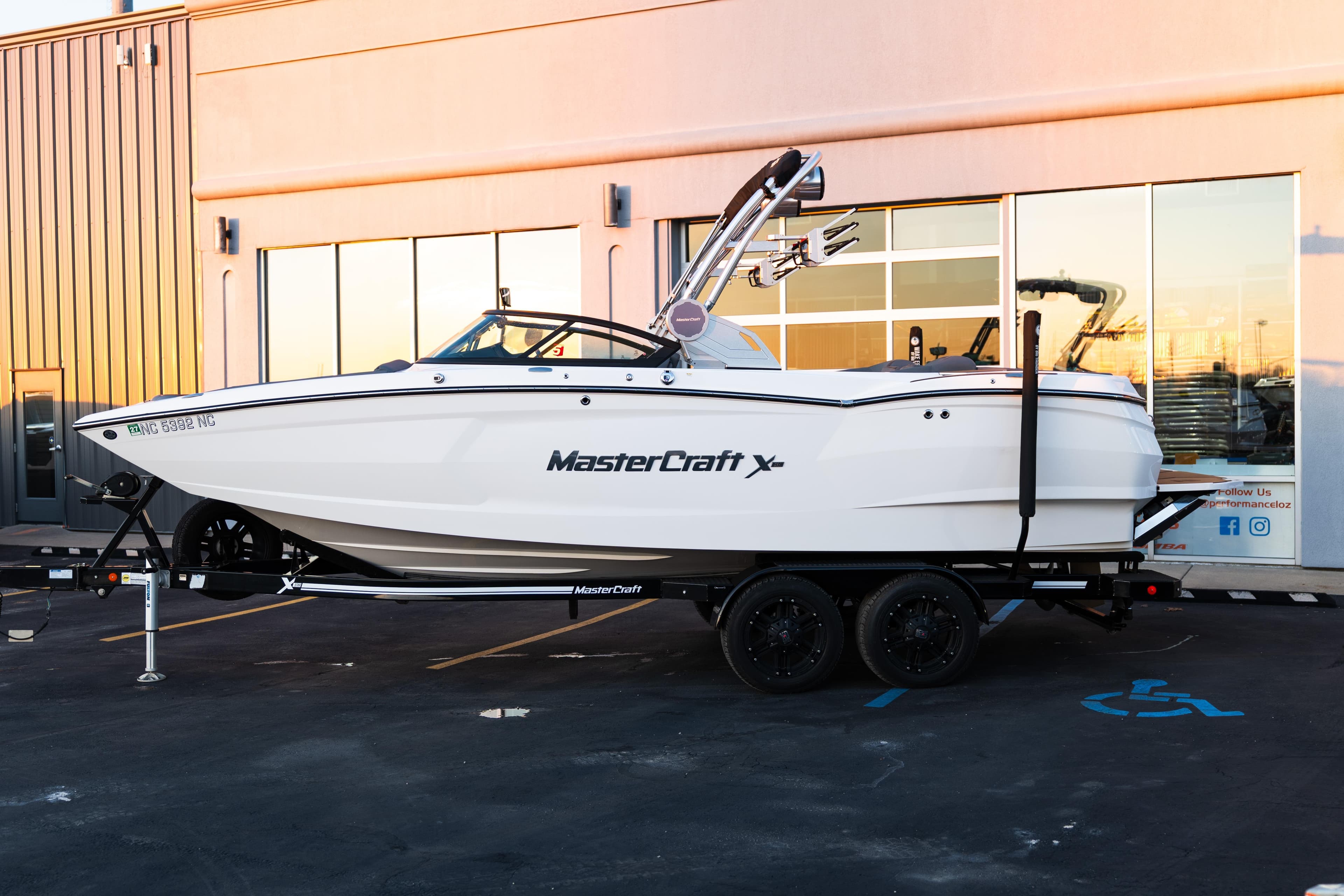 2022 MasterCraft XStar boat on trailer outside a modern building.