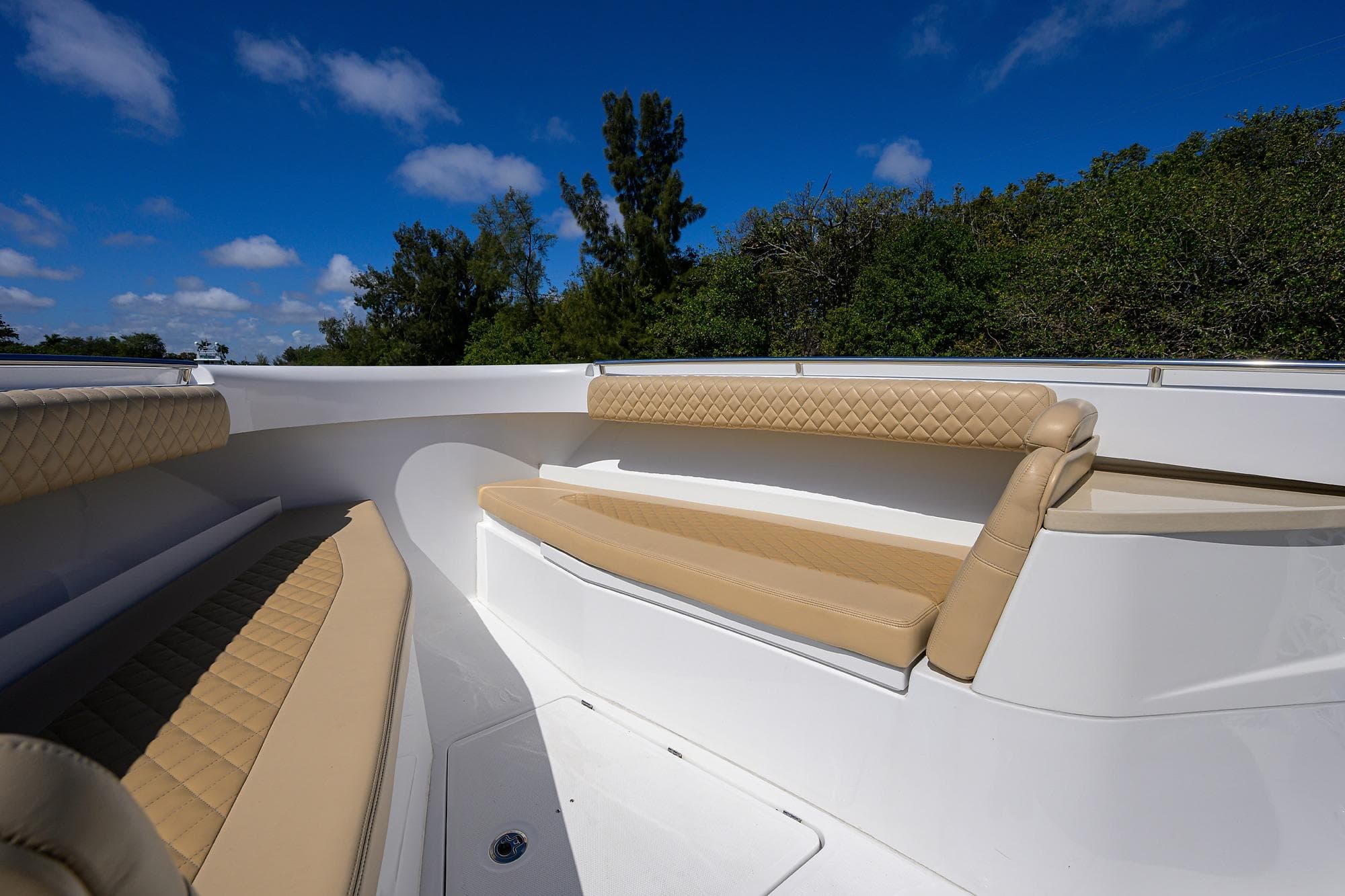 2024 HCB 39 Speciale boat interior with beige seating under blue sky.