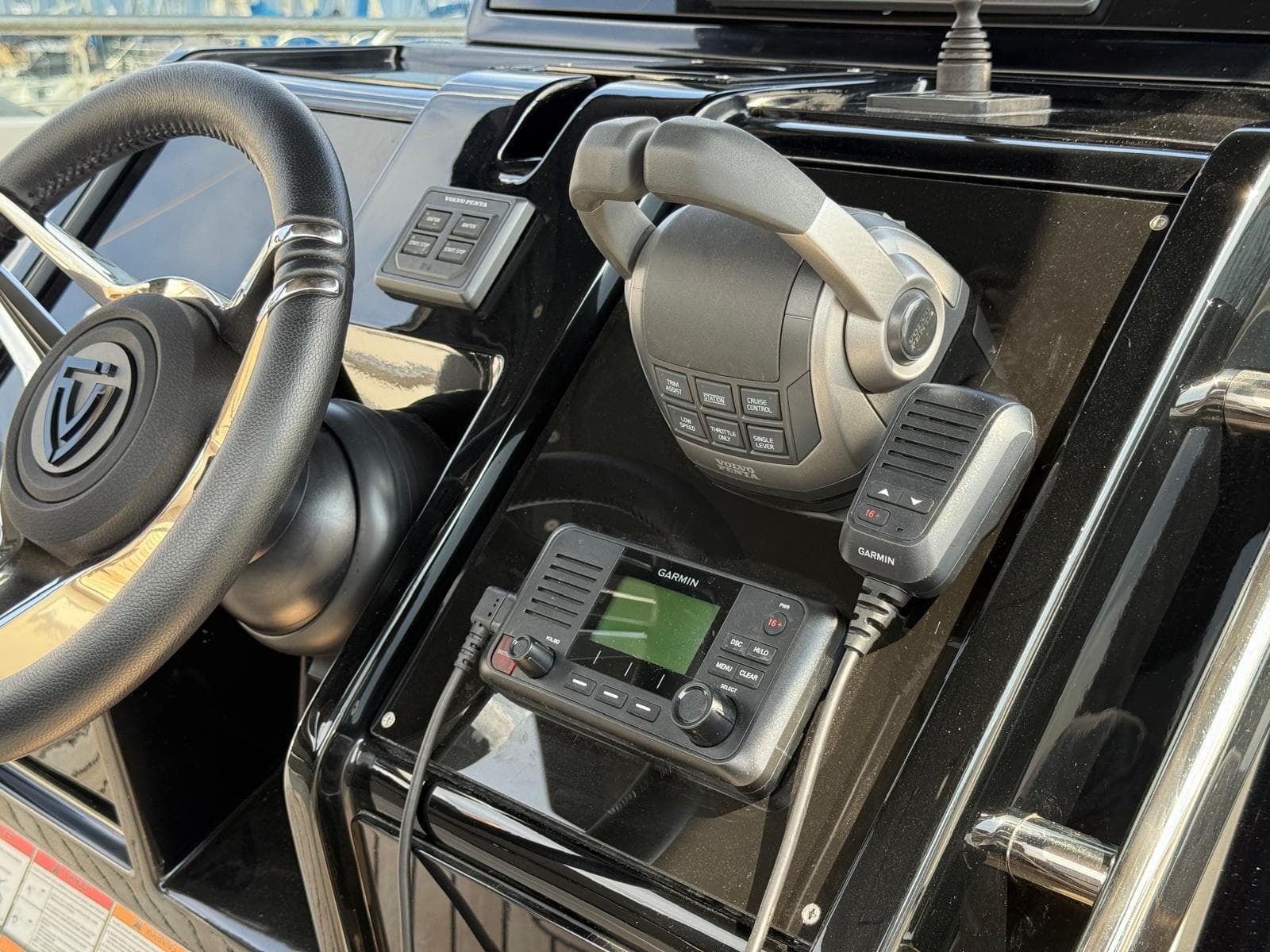 2024 FIM 340 boat dashboard with steering wheel and Garmin marine radio.