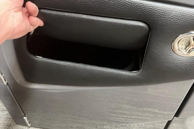 Hand opening storage compartment in 2026 MONACO 235SFL vehicle interior.