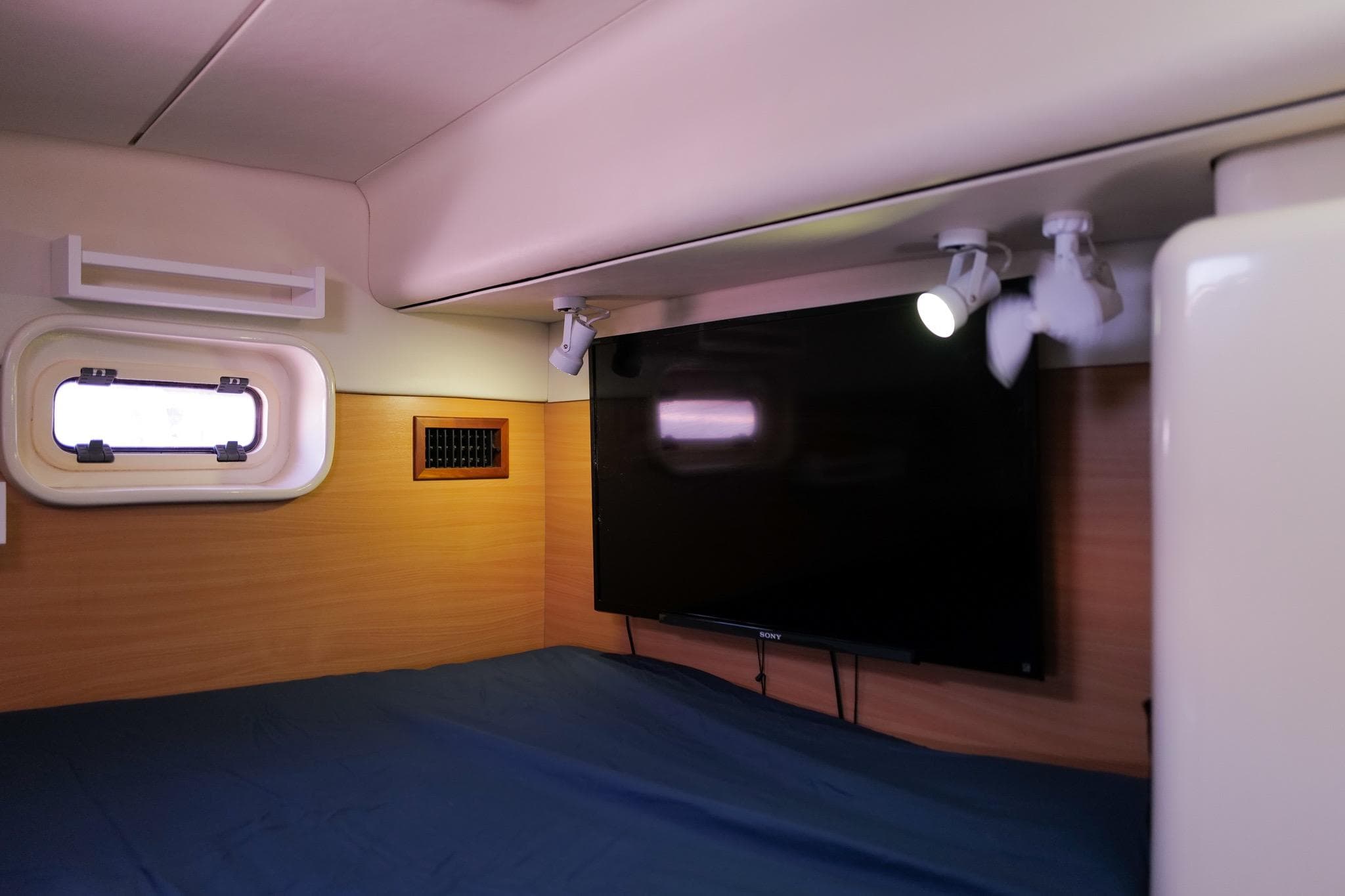 Interior cabin of a 2006 Leopard 43 yacht with a mounted TV and spotlight.