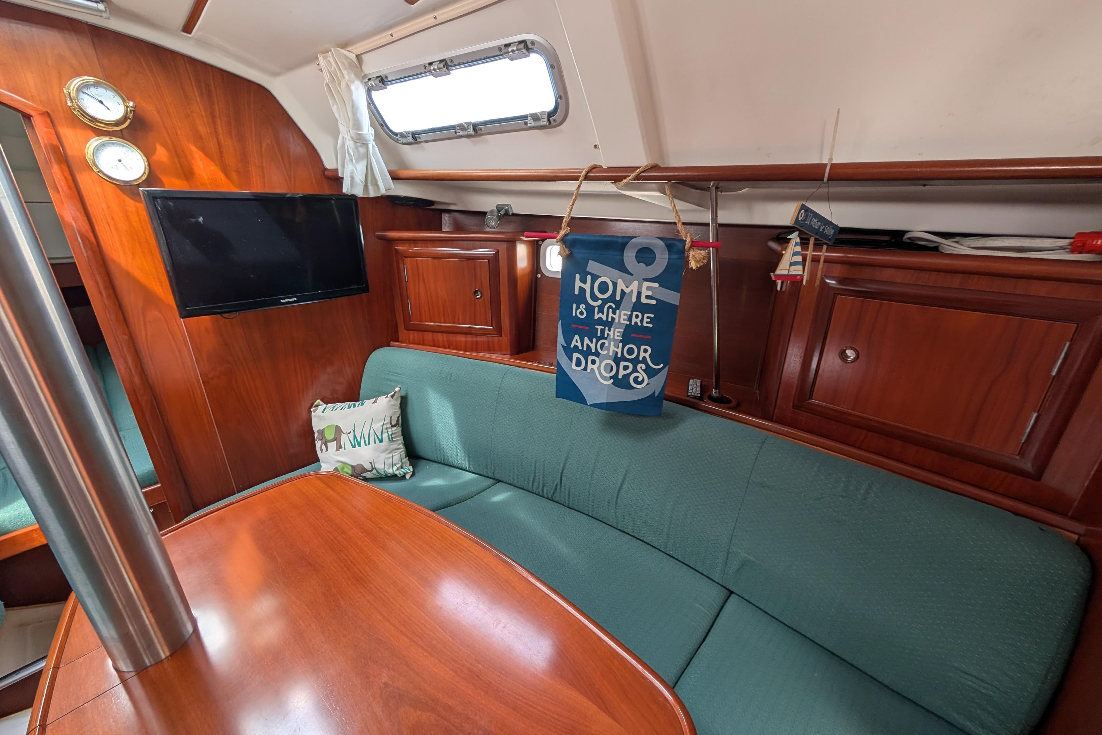 Interior of 2003 Beneteau 331 sailboat with cozy seating and nautical decor.