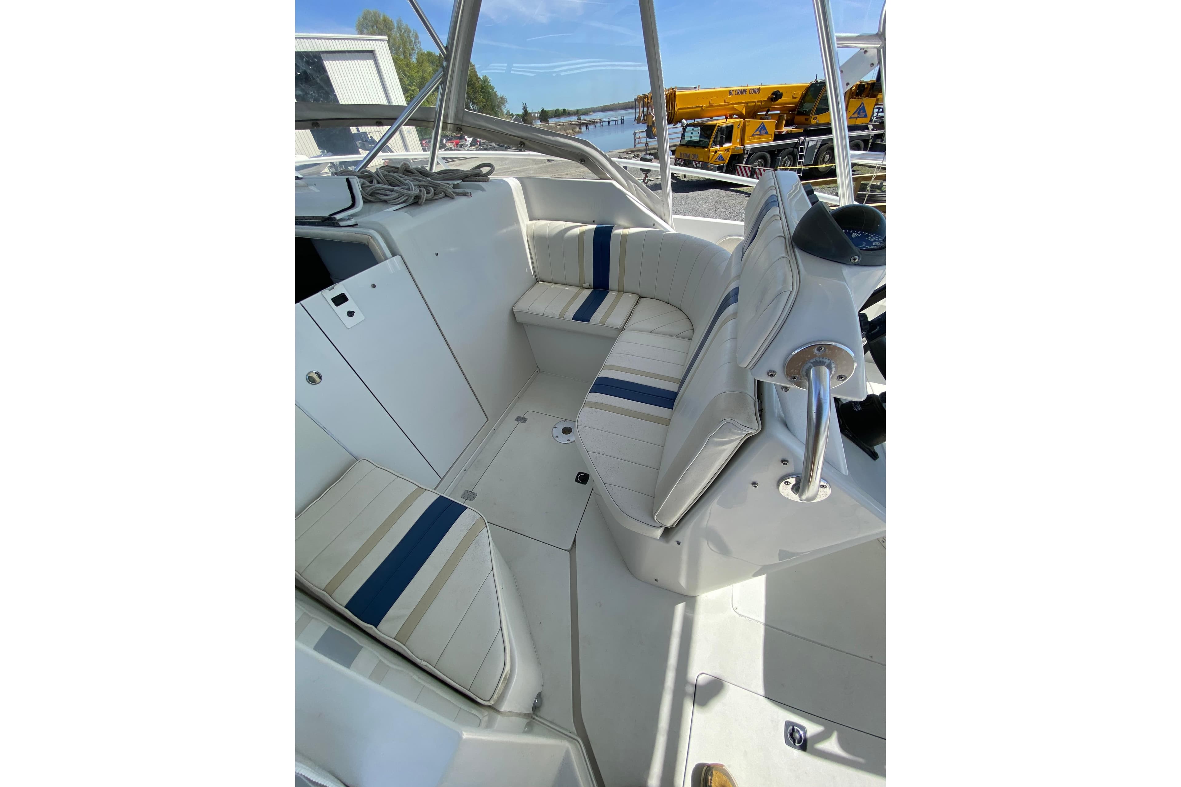 1996 Intrepid 337 boat interior with white and blue seating, docked near water.