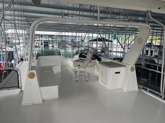 Upper deck of a 2007 Thoroughbred houseboat in a marina.