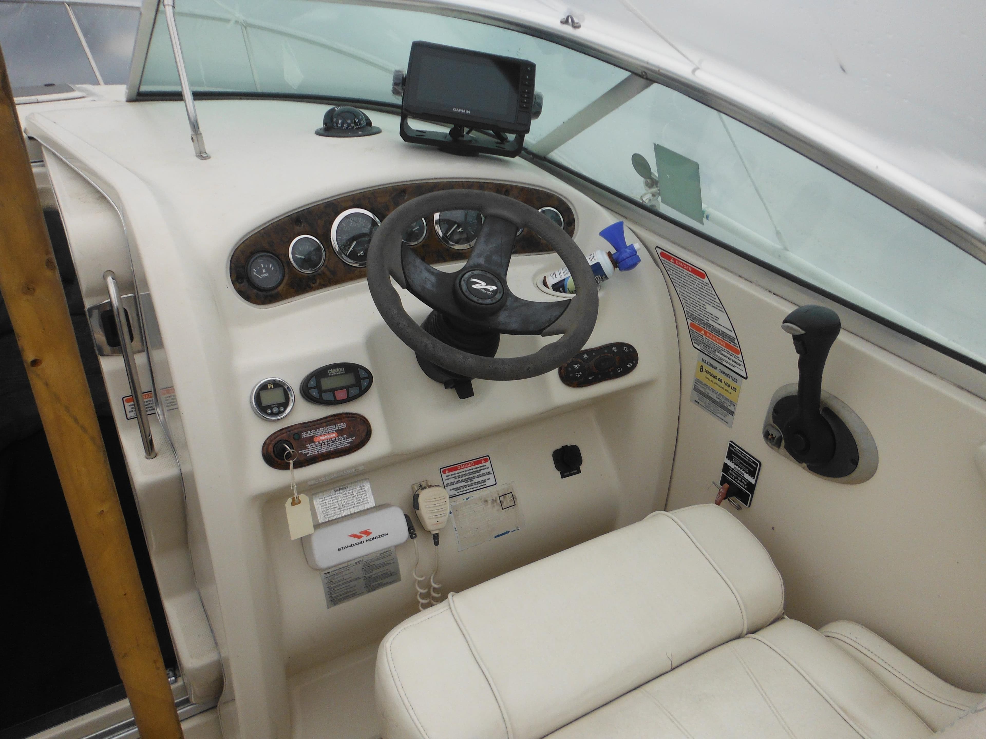 Interior cockpit of 2004 Sea Ray 215 Weekender boat with steering wheel and controls.