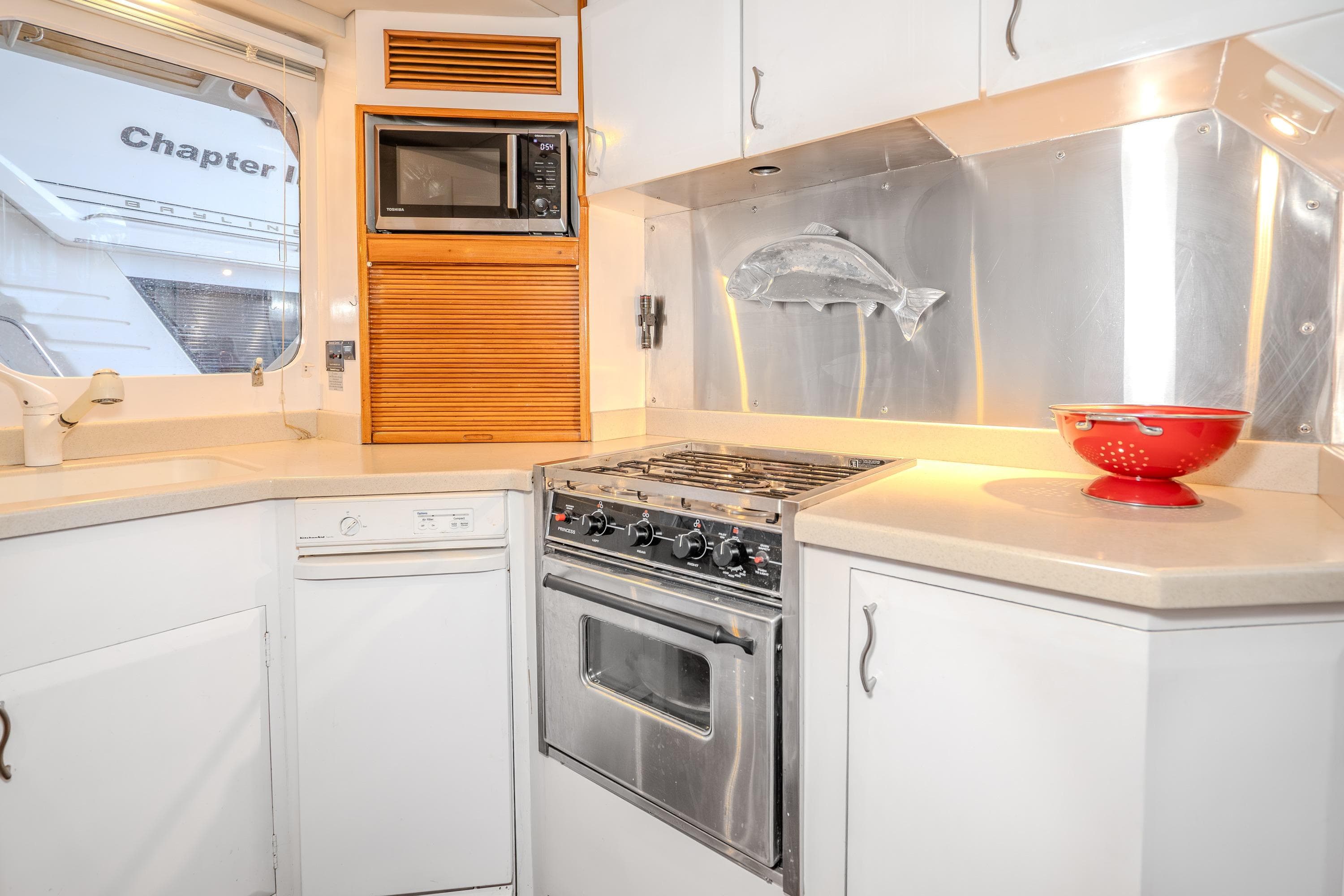 1973 American Marine Alaskan 53 yacht kitchen with stove, microwave, and fish decor.