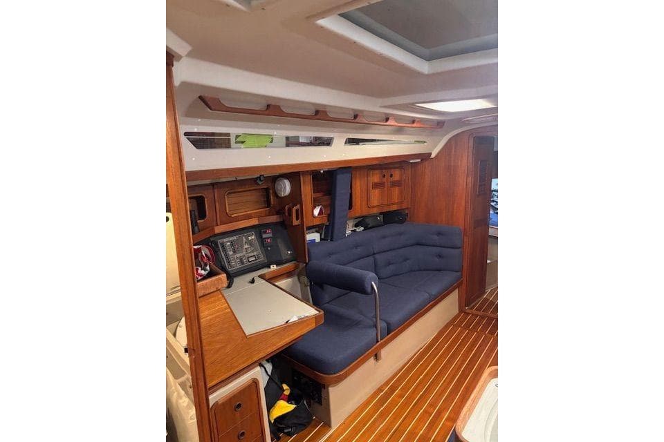 Interior of a 1990 C&C 37/40 Plus sailboat with wooden finish and blue seating.