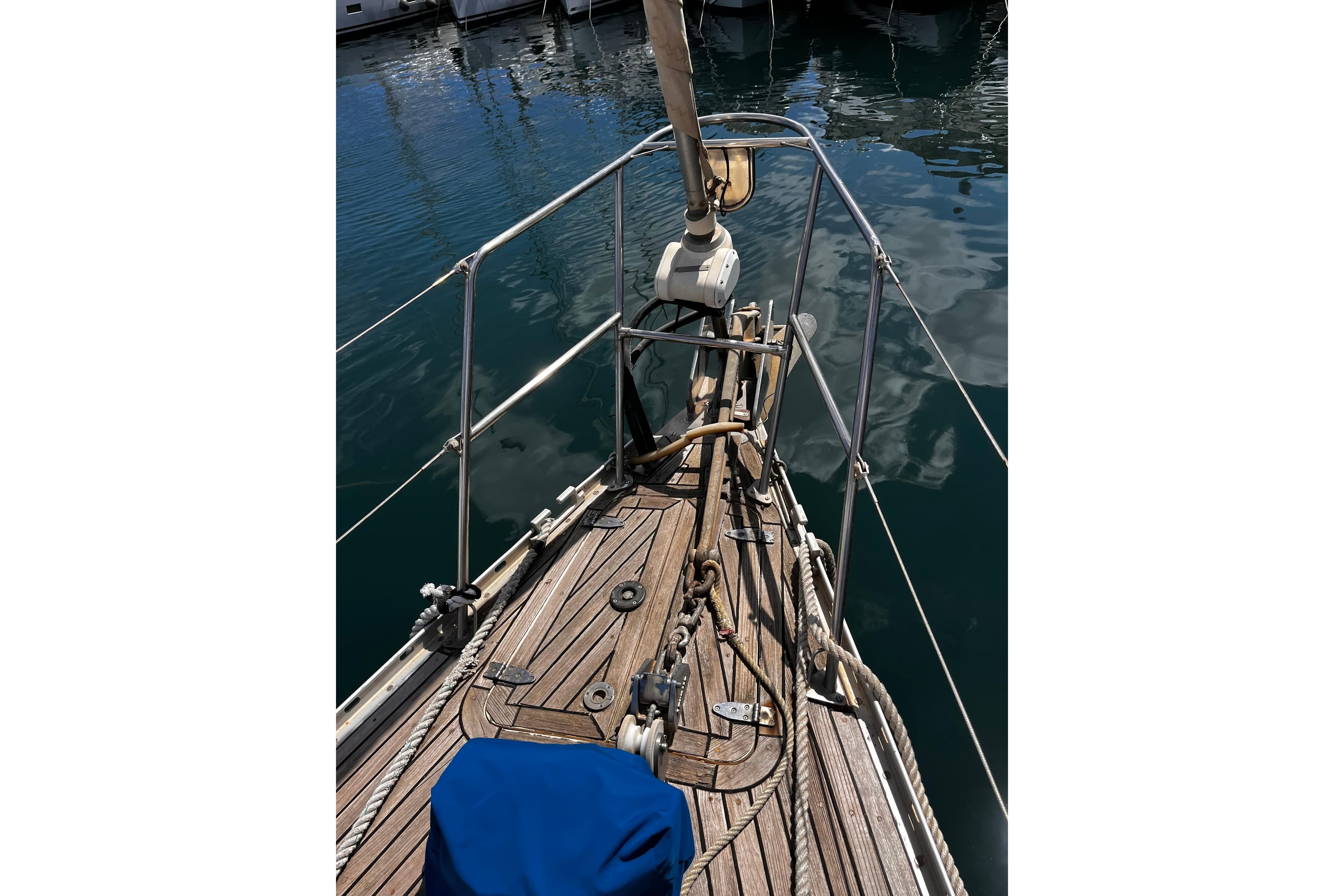 Bow view of 1989 Oyster 53 Deck Saloon yacht with wooden deck and mooring ropes.