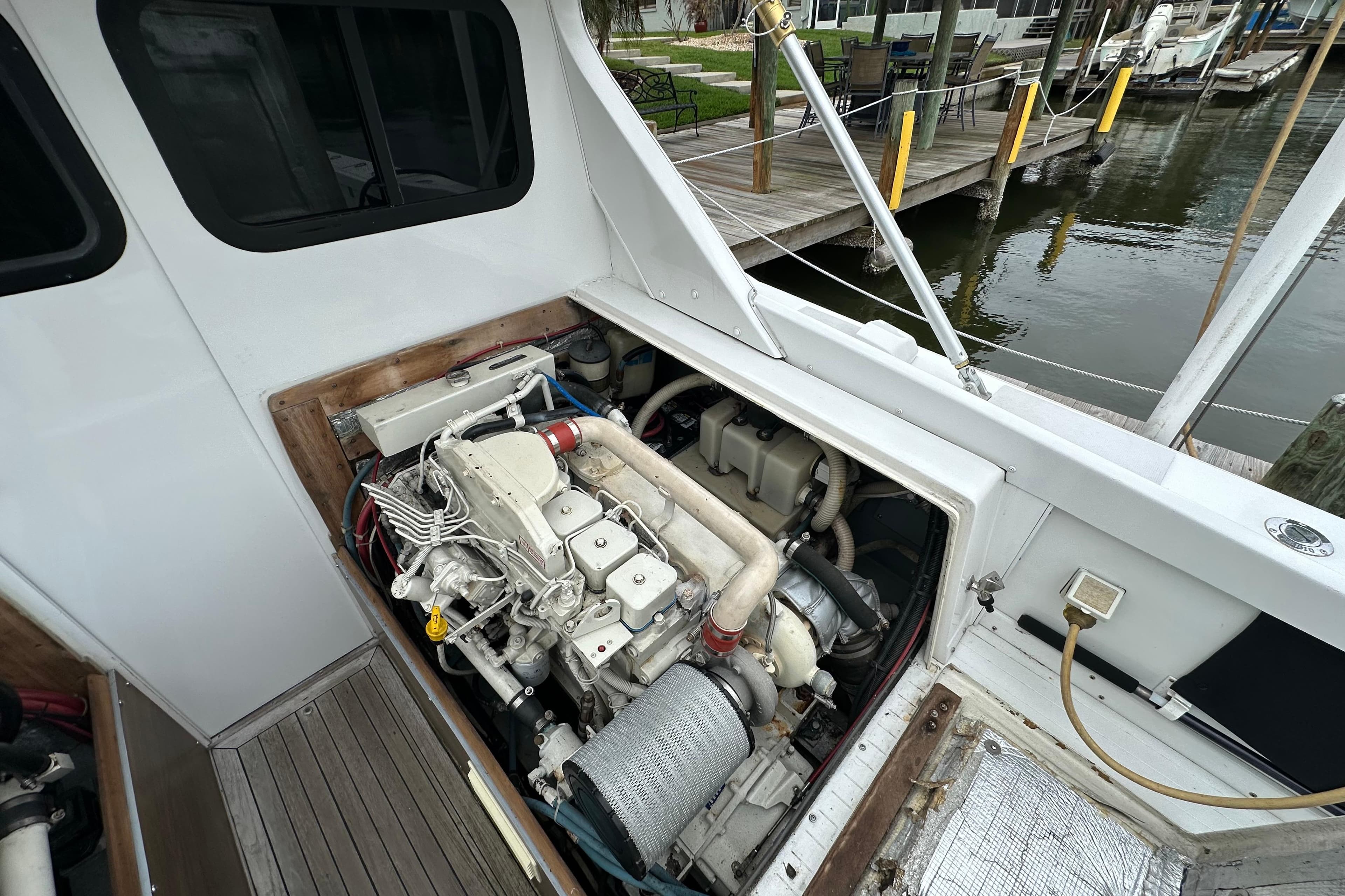 Engine compartment of a 1975 Bertram 31 boat, docked by the water.