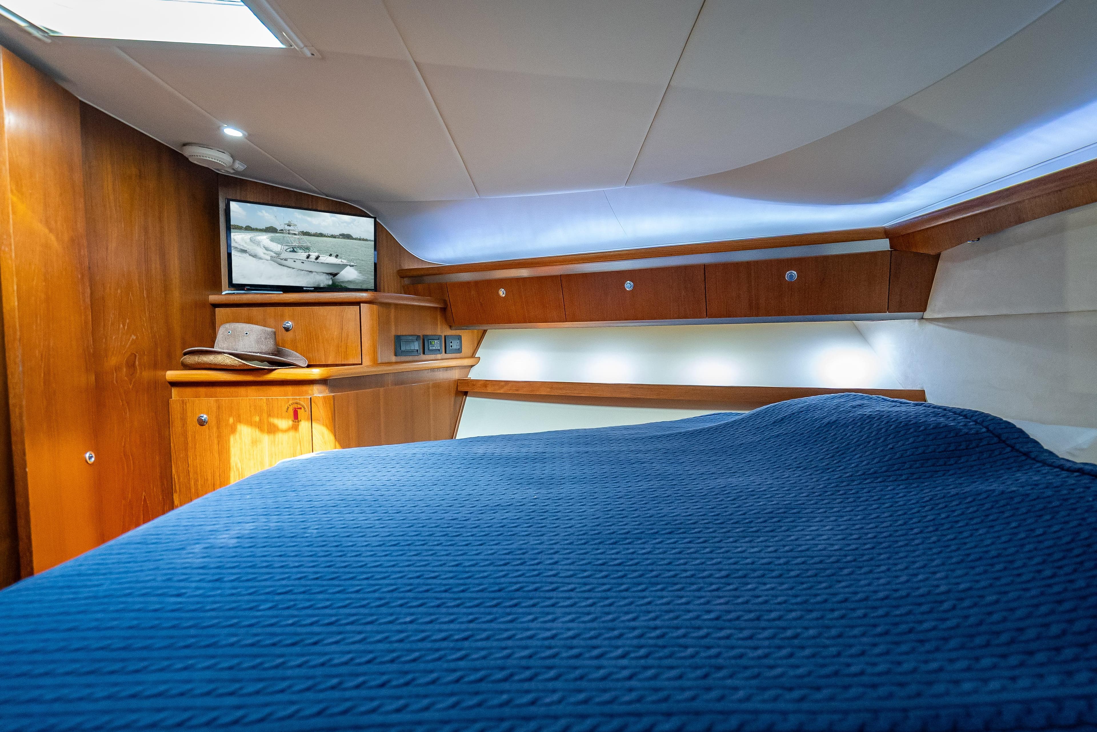 2006 Tiara Yachts 4200 Open cabin with blue bedding and wooden interior.