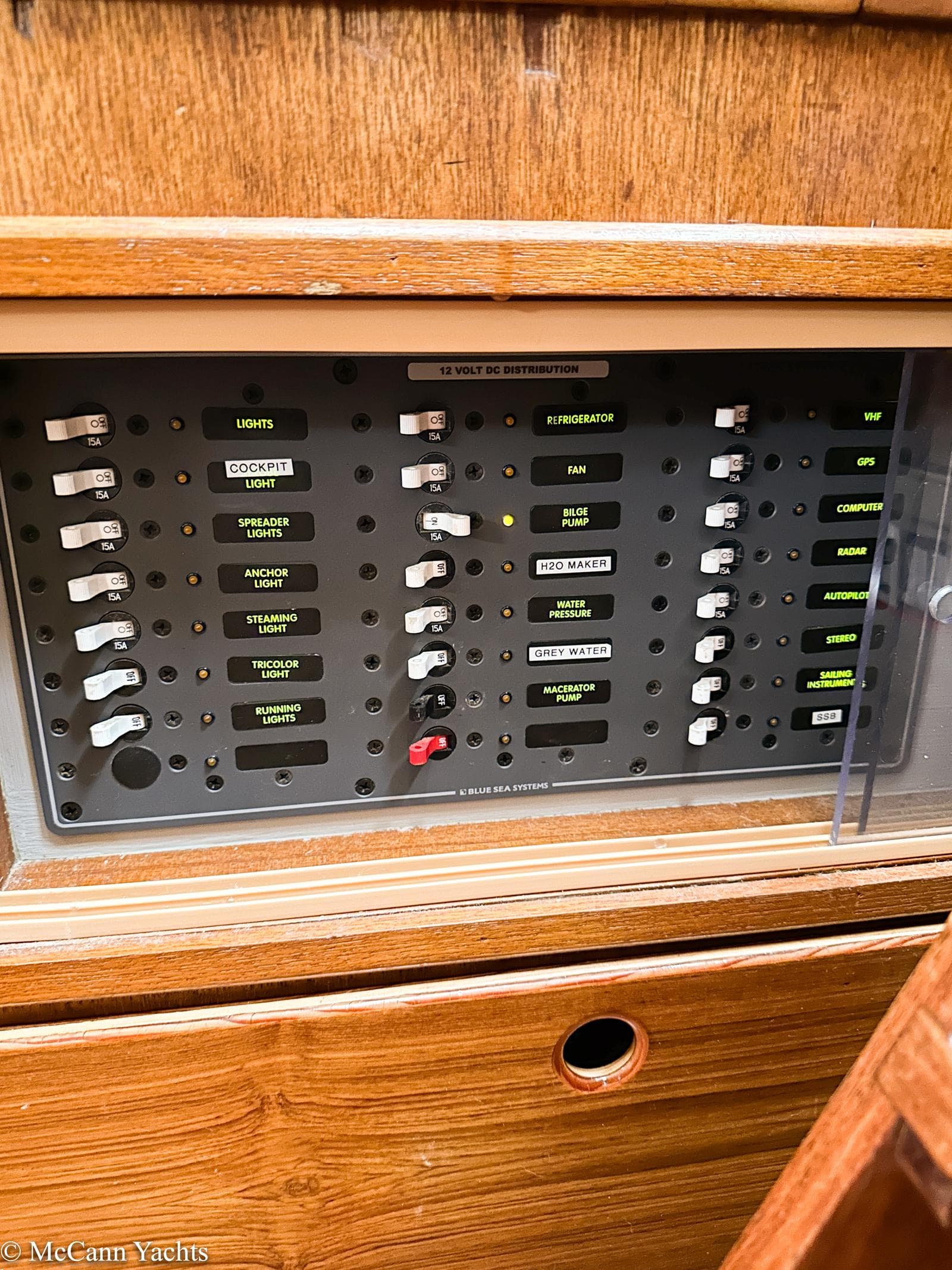 Electrical control panel on a 1973 Challenger 40 yacht, featuring labeled switches and wooden casing.