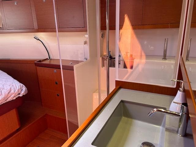 Interior of 2013 Beneteau 48 yacht featuring a modern bathroom and cozy bedroom.
