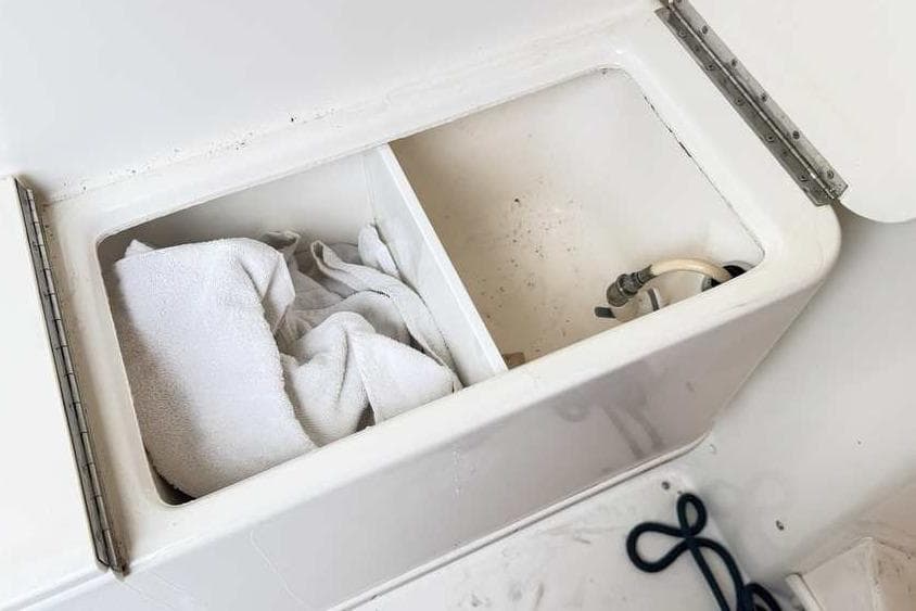 Storage compartment on a 1998 Sea Ray 370 Express Cruiser with towel and hose.