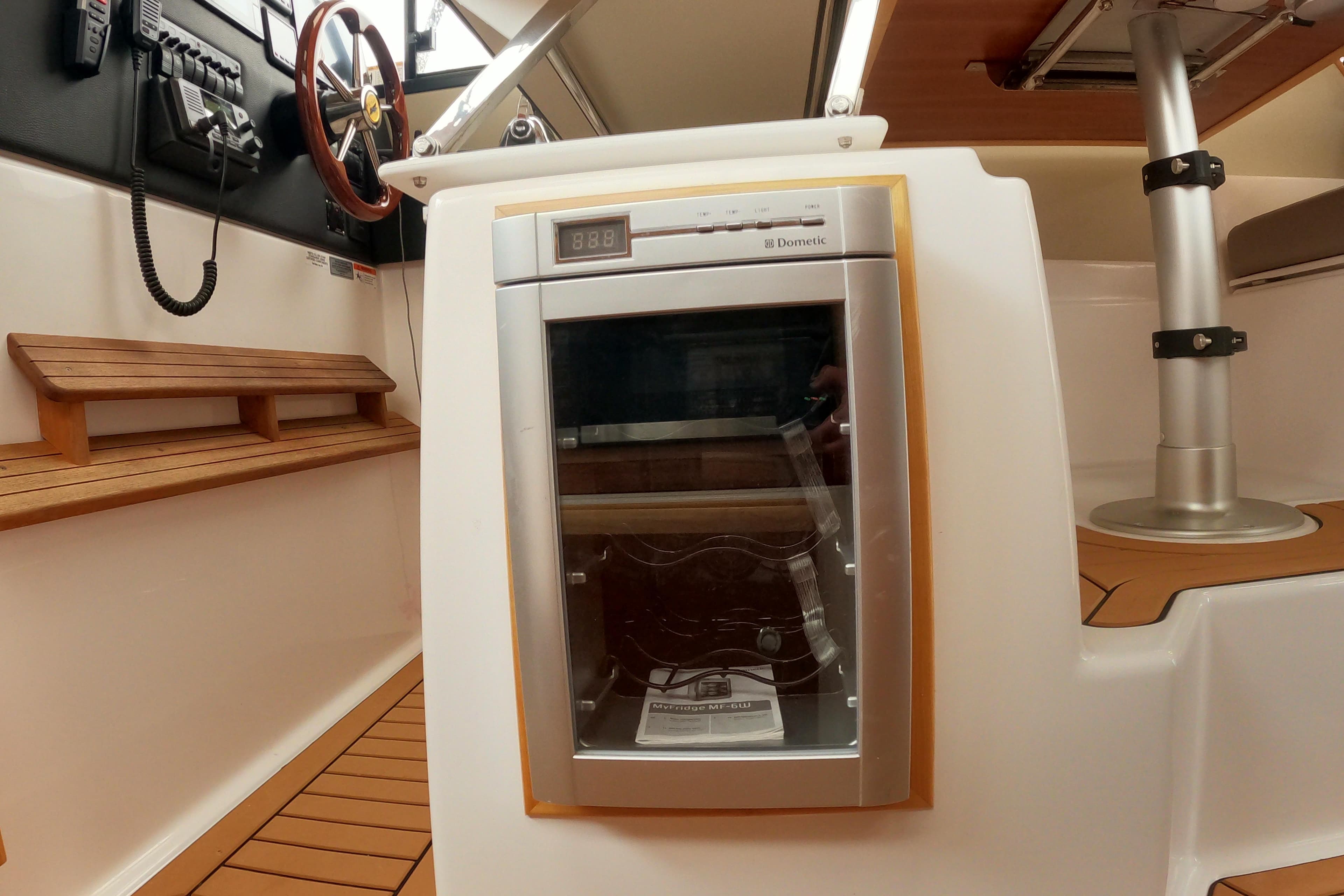 2019 Cutwater C-30 Sedan interior with Dometic fridge and wooden seating.