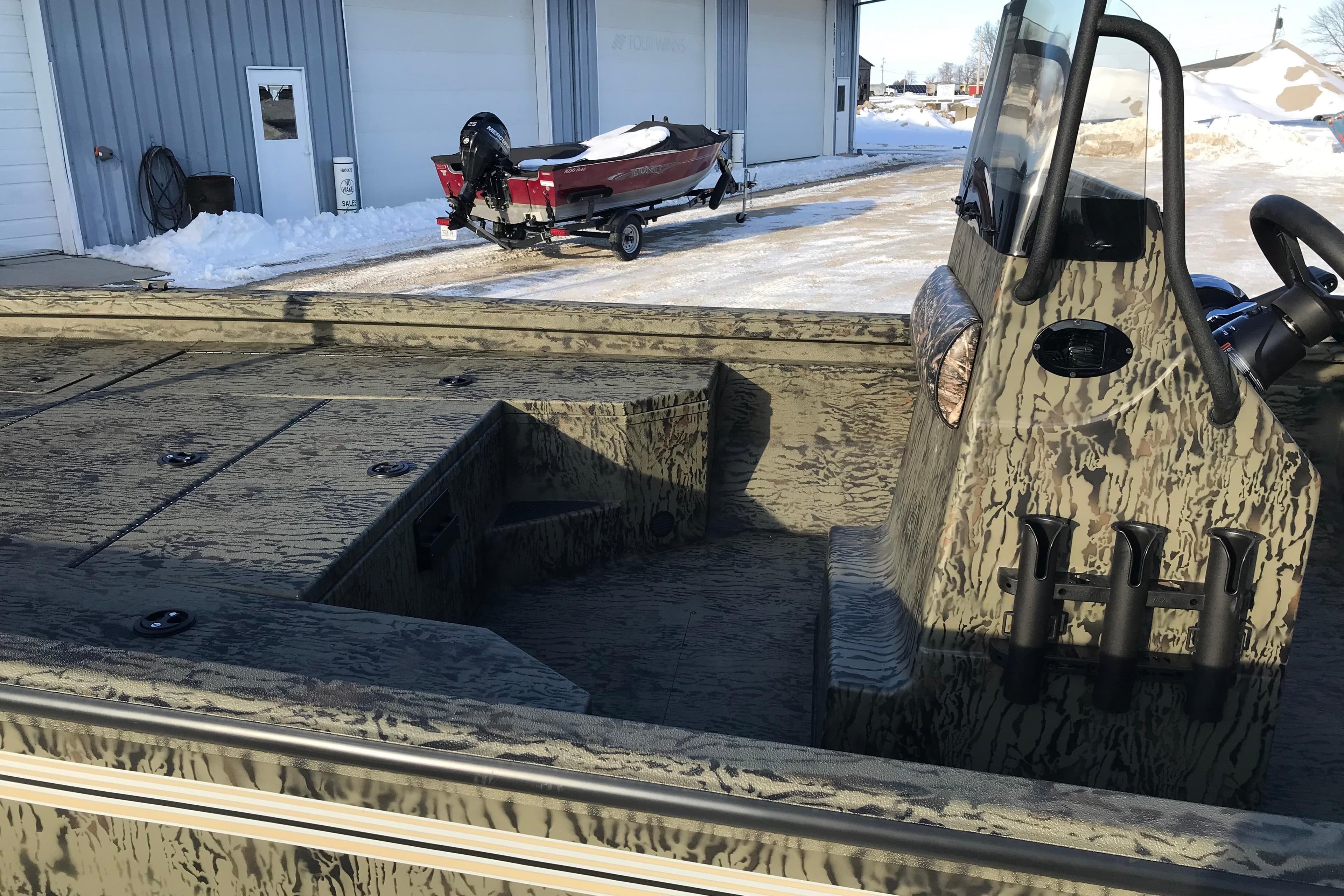 2026 Ranger RB200 boat with camouflage design, parked near a snowy building.