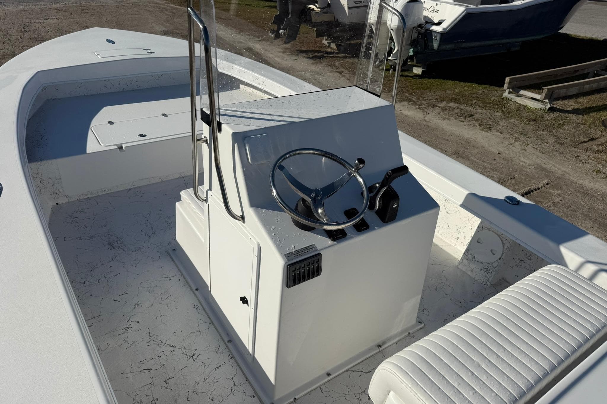 2026 C-Hawk 25 Center Console boat with steering wheel and seating, docked outdoors.