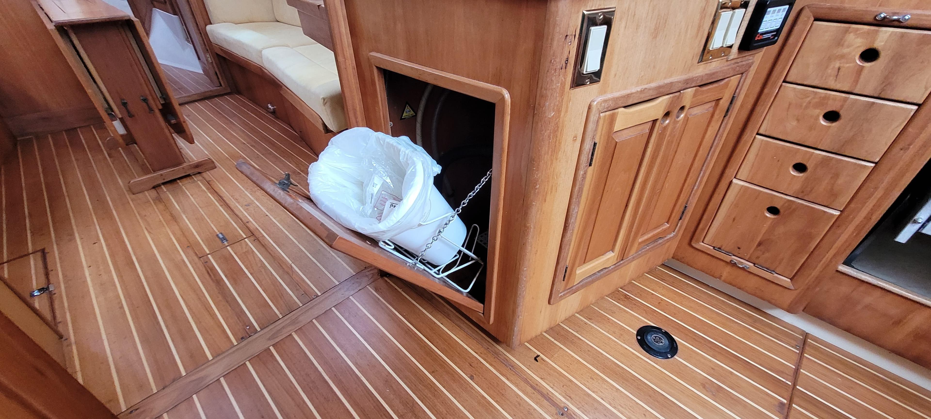 Wooden interior of 1997 Saga 43 boat with storage compartments and seating area.