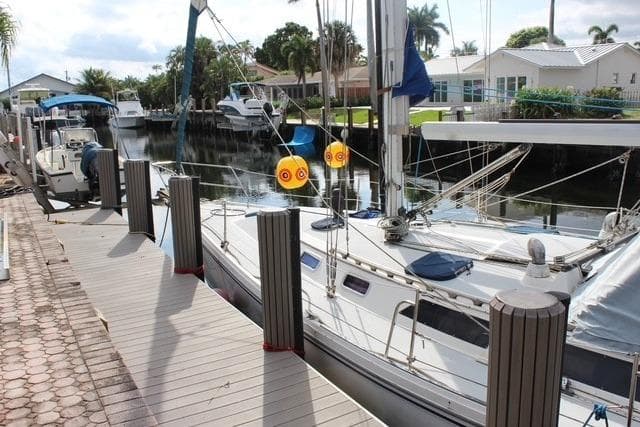 1989 Catalina 42 sailboat docked in a serene canal setting.