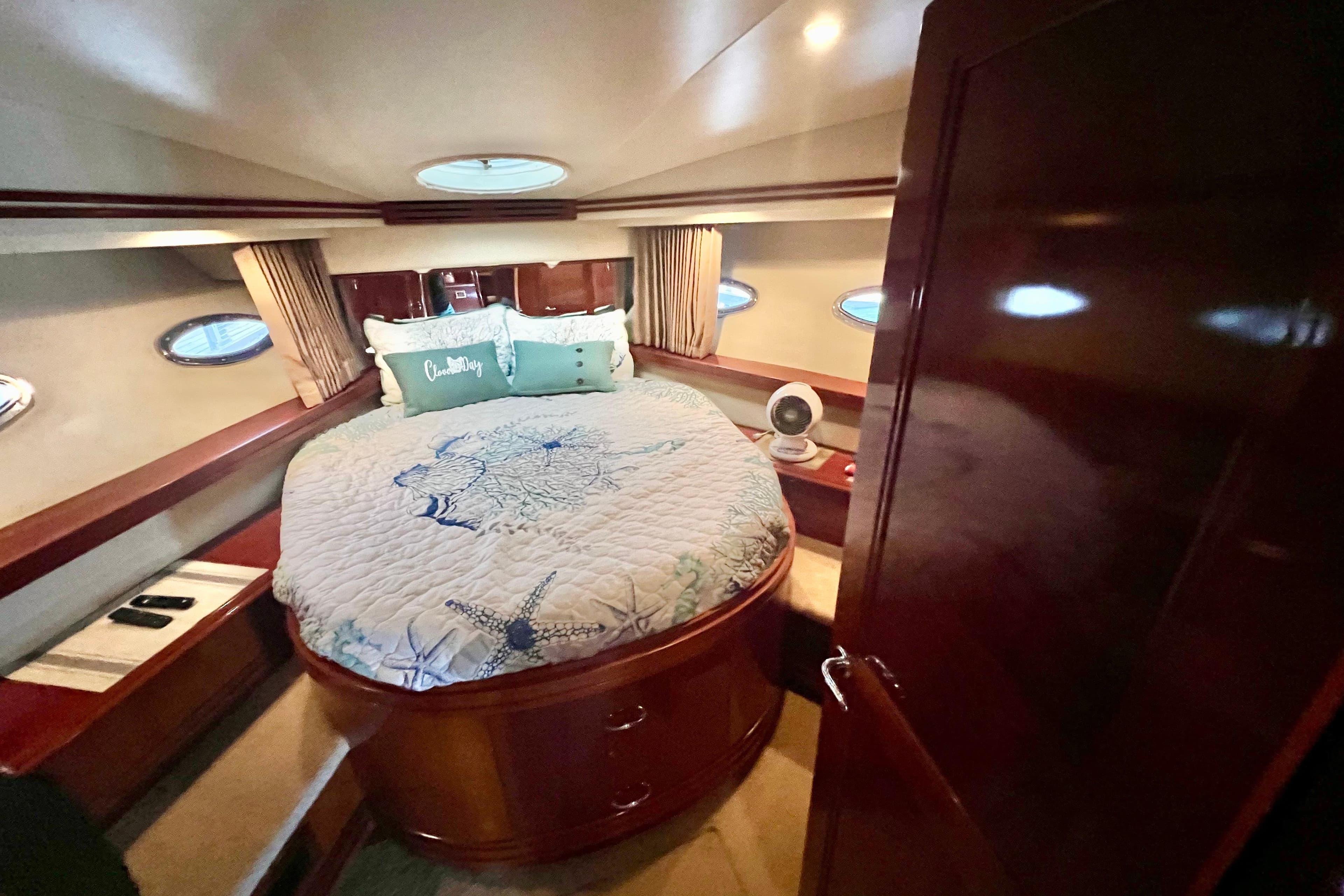 Luxurious bedroom interior of 2005 Carver 56 Voyager yacht with elegant bedding.