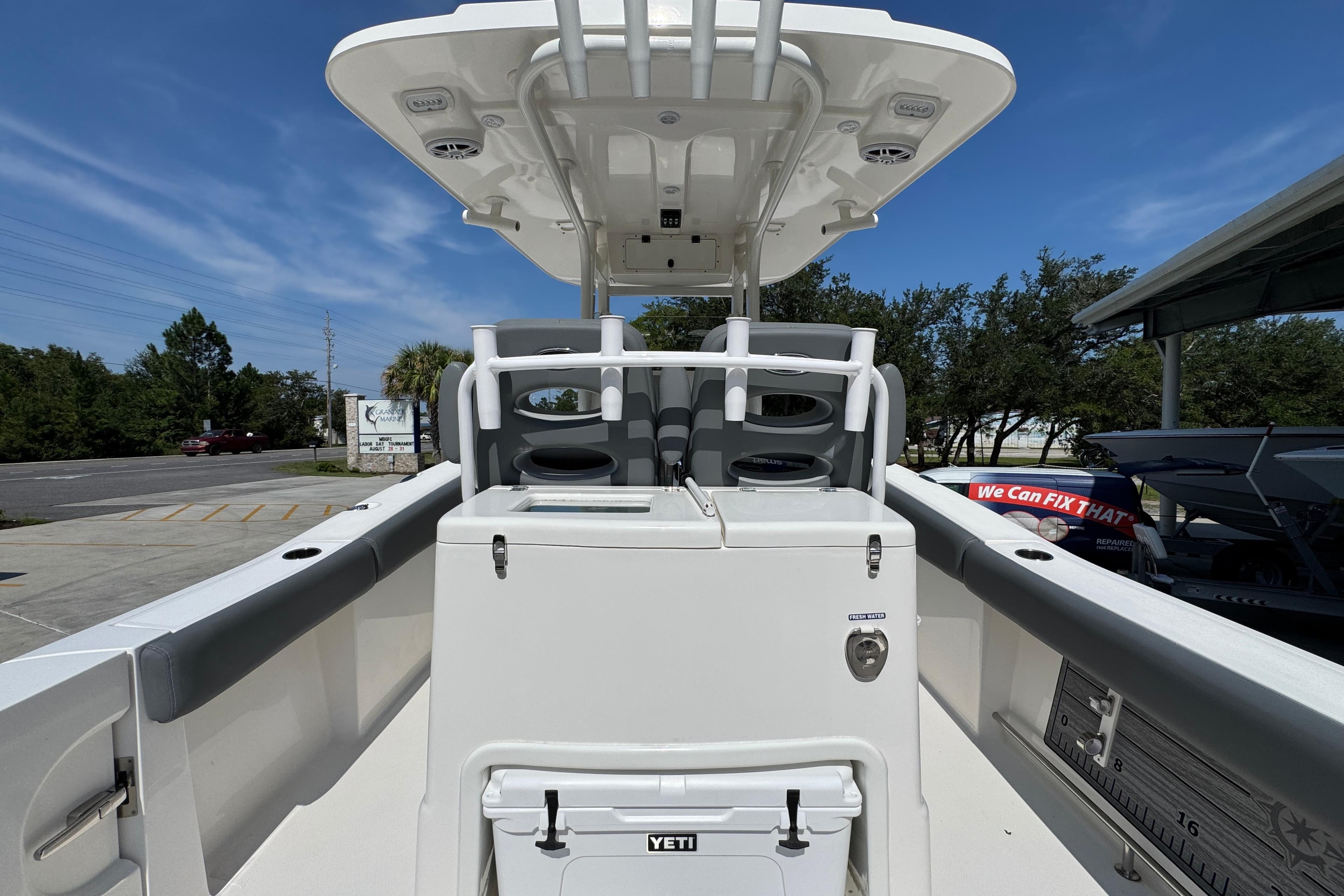 2024 NauticStar 292 Legacy boat interior with seating and storage under a clear blue sky.