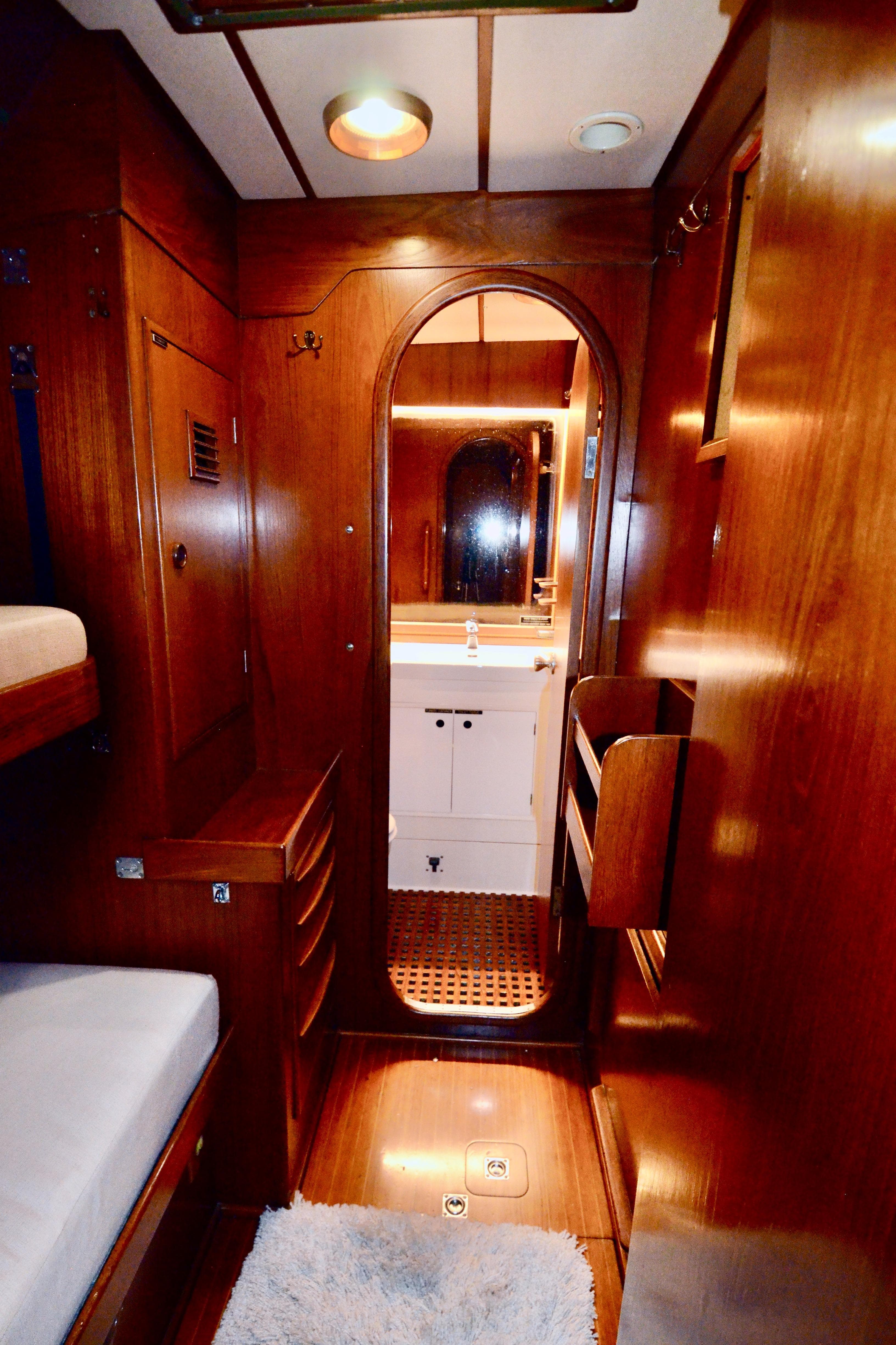 Luxurious wooden interior of 1983 Nautor Swan 651 yacht with cozy cabin and bathroom.