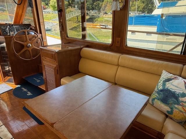 Interior of 1983 Ocean Alexander 43 Flush Aft Deck yacht with beige seating and wooden accents.