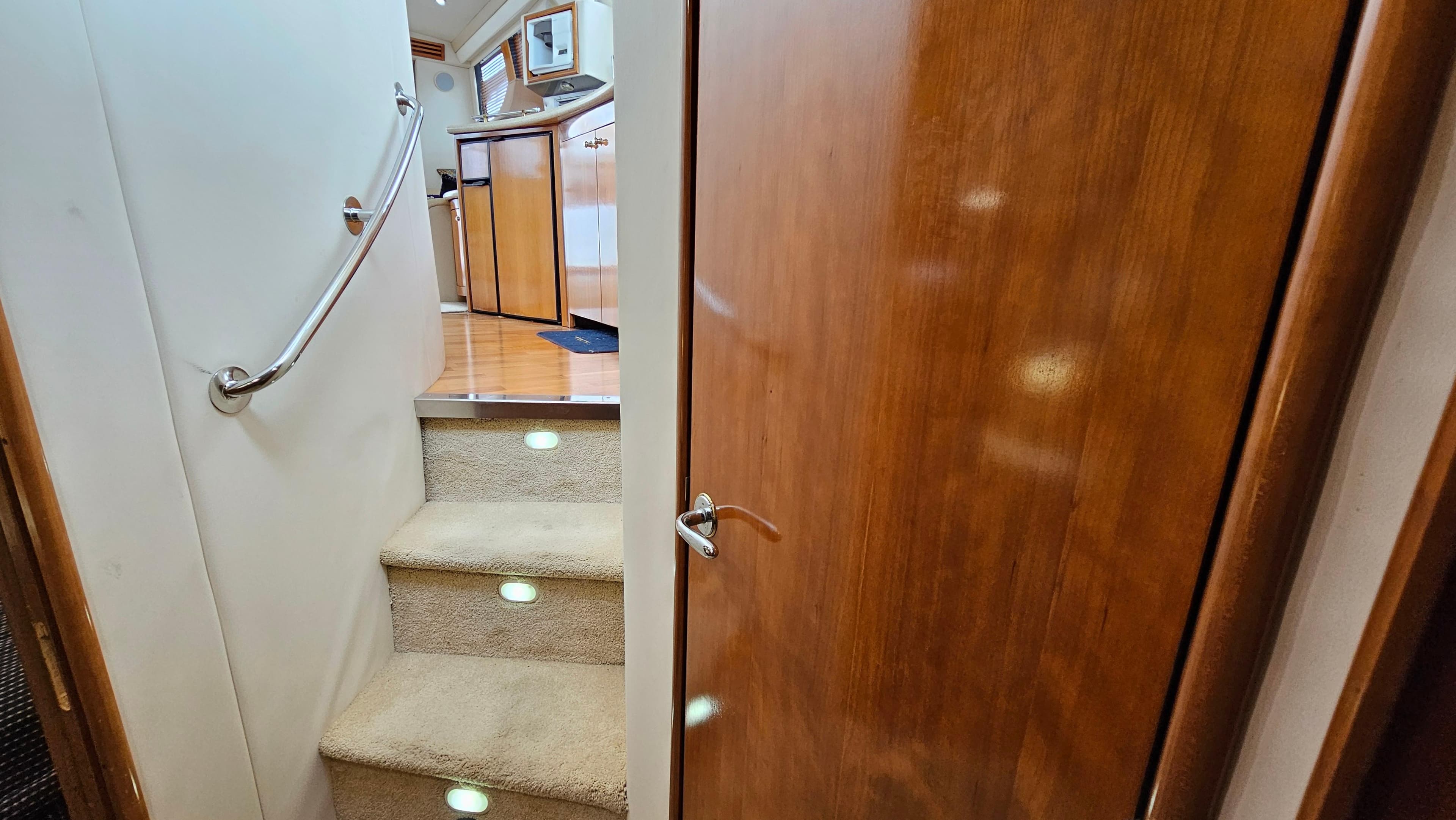 Interior of 2000 Carver 450 Voyager Pilothouse with carpeted stairs and wooden door.
