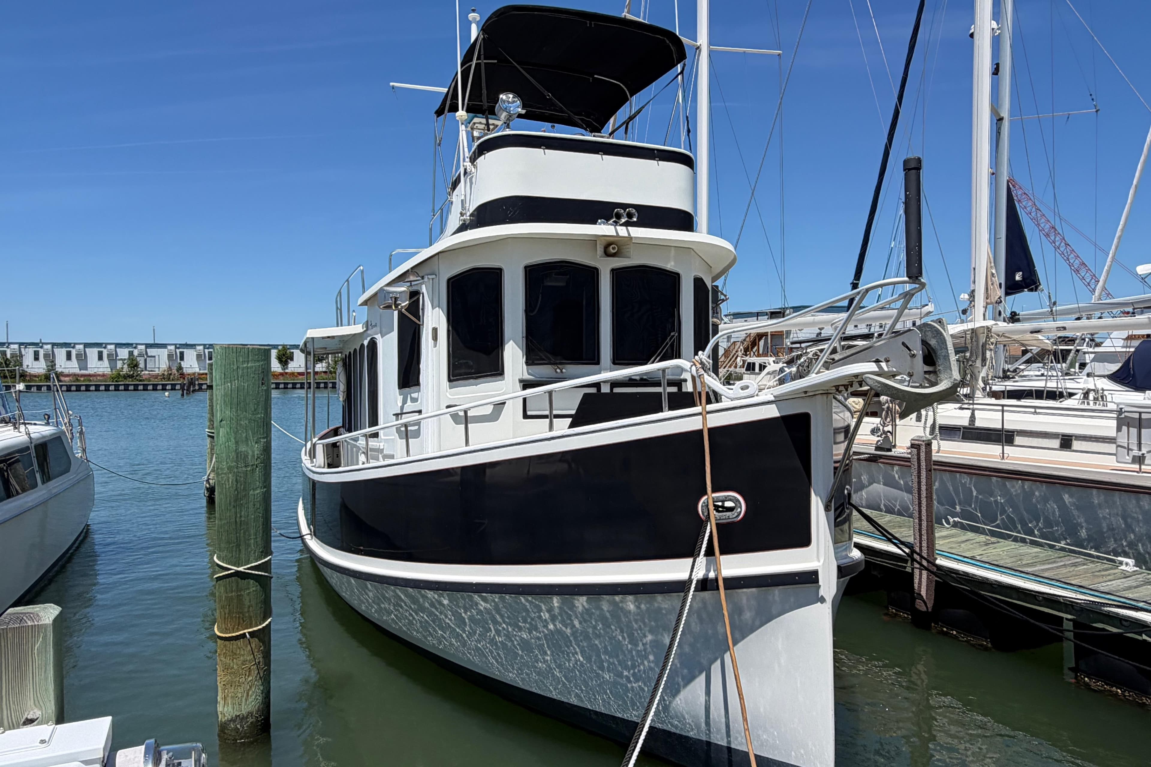 1985 Gozzard PILGRIM boat docked at marina under clear blue sky.
