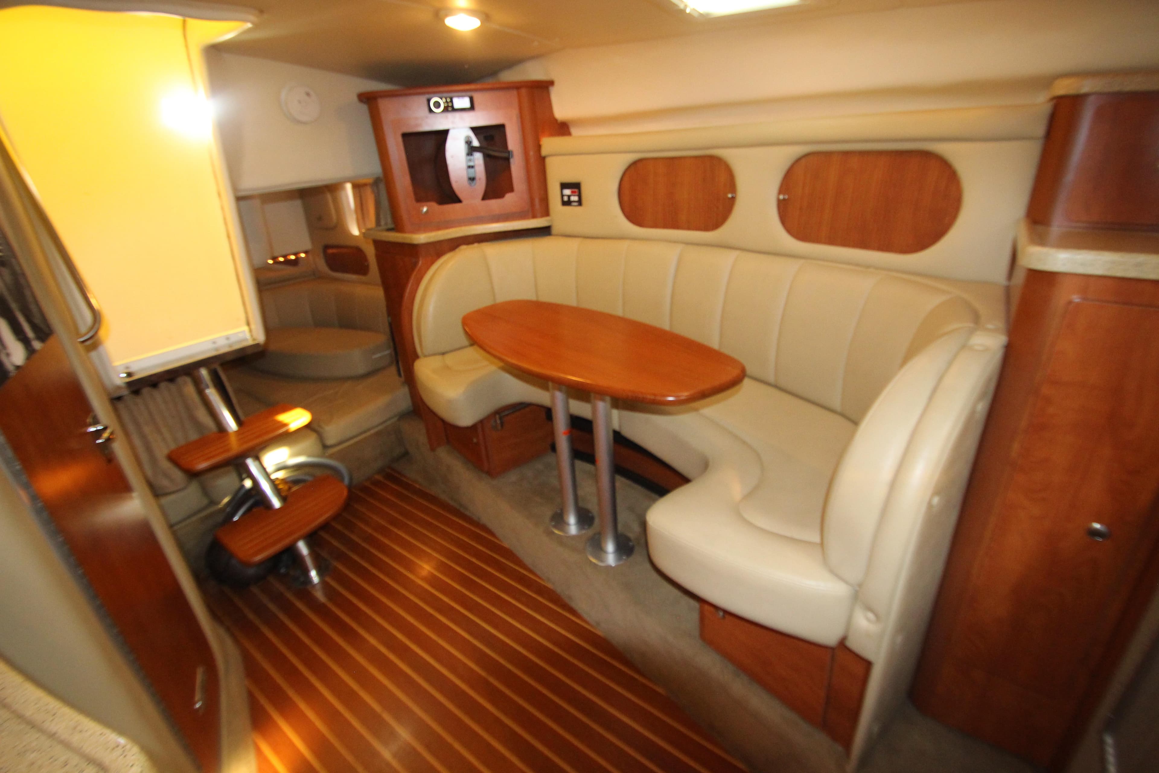 2006 Rinker 320 Express Cruiser interior with beige seating and wooden accents.