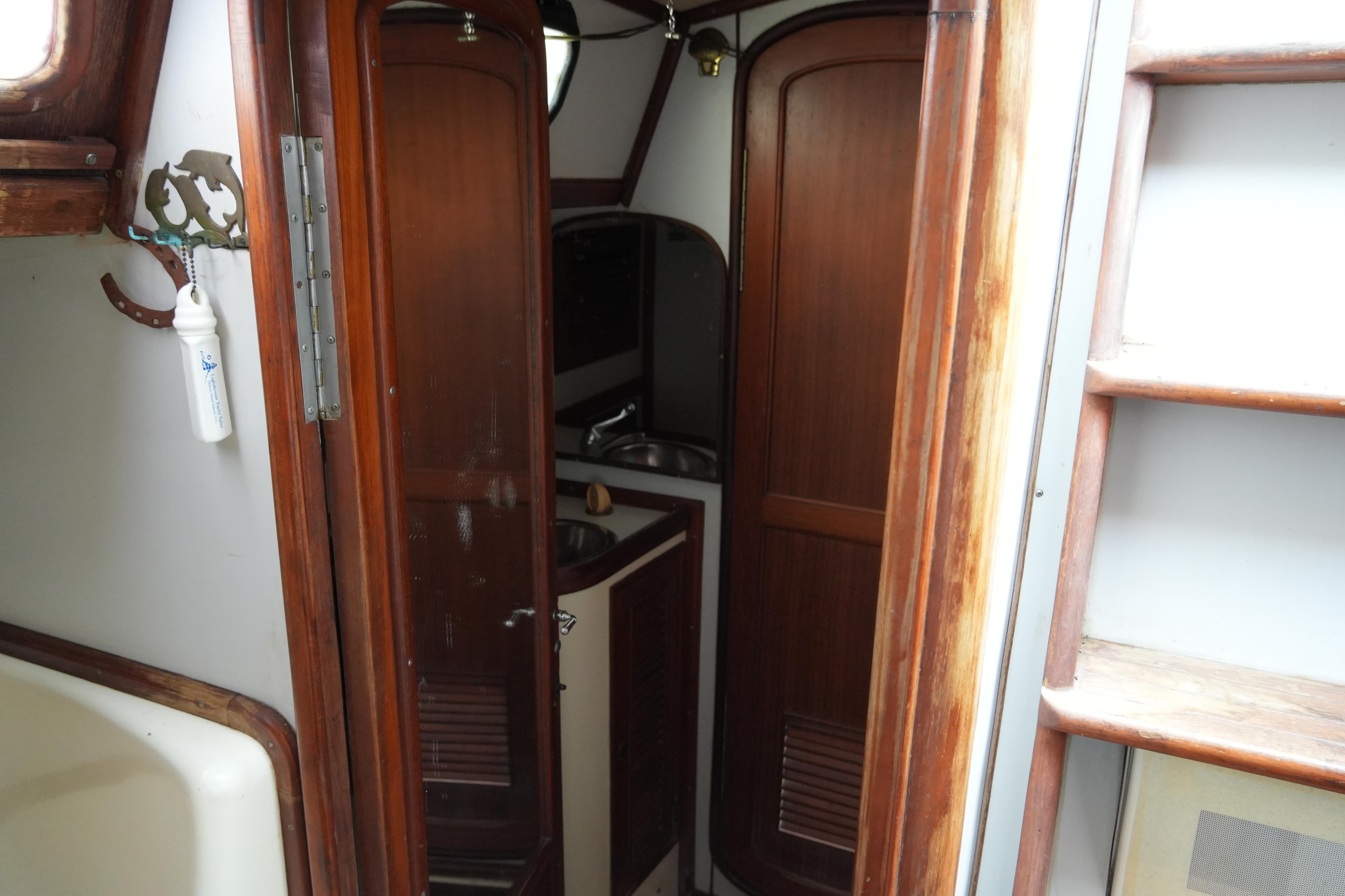 Interior of 1980 Lafitte 44 Cutter sailboat, featuring wooden cabinetry and compact design.