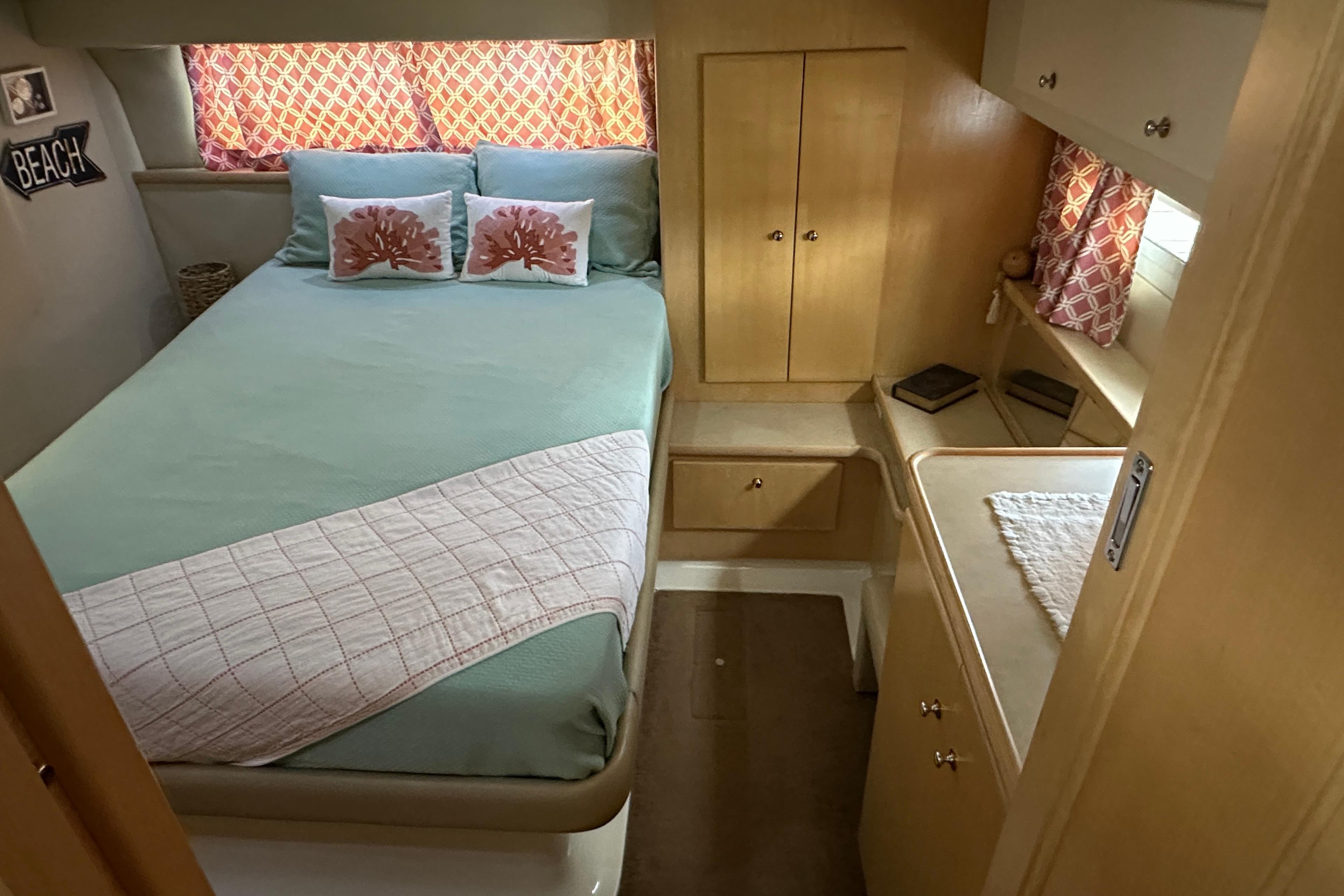 1998 Carver 445 Aft Cabin Motor Yacht bedroom with cozy bed and wooden cabinetry.