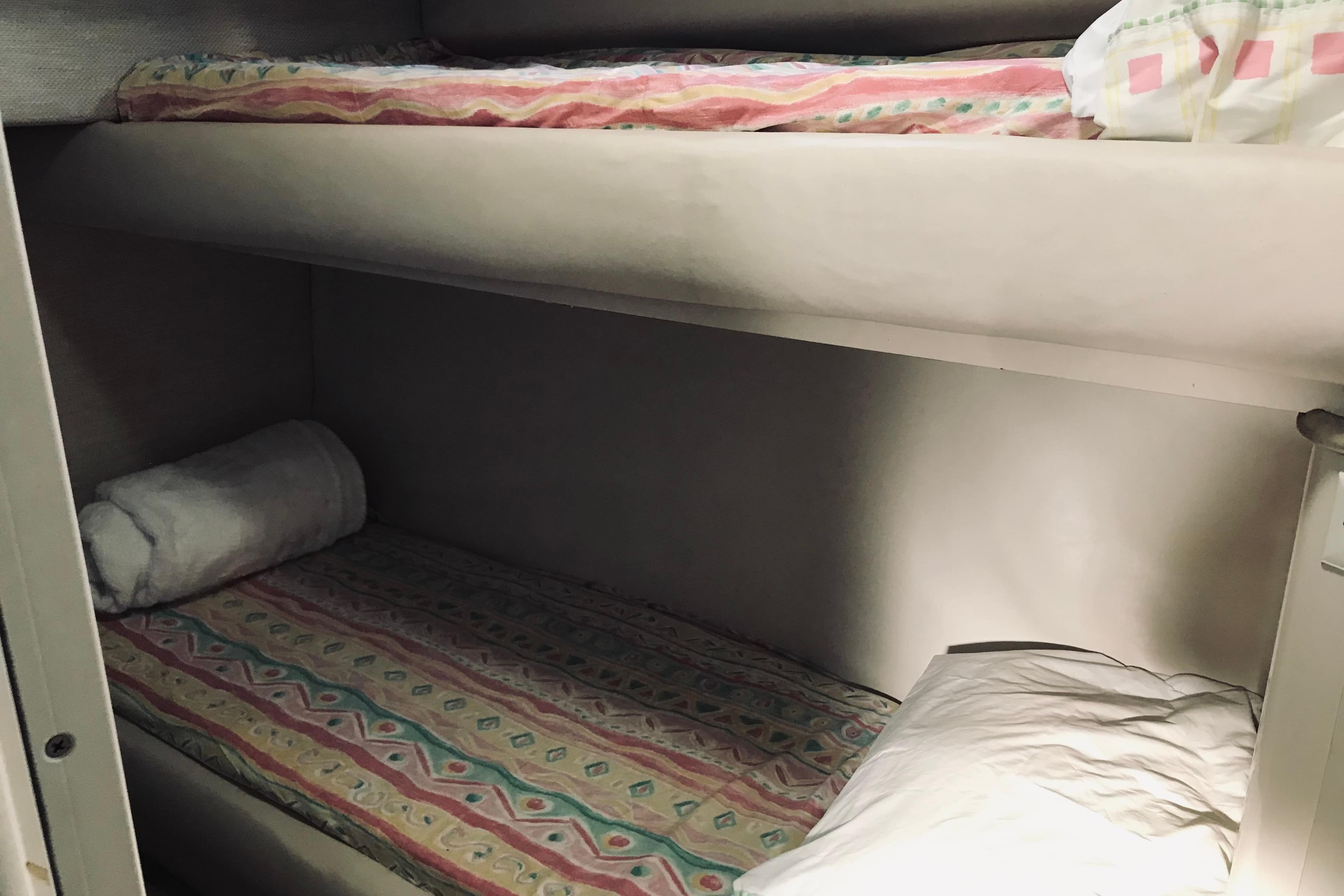 Bunk beds in 1995 Sea Ray 550 Sedan Bridge yacht cabin, featuring colorful bedding.