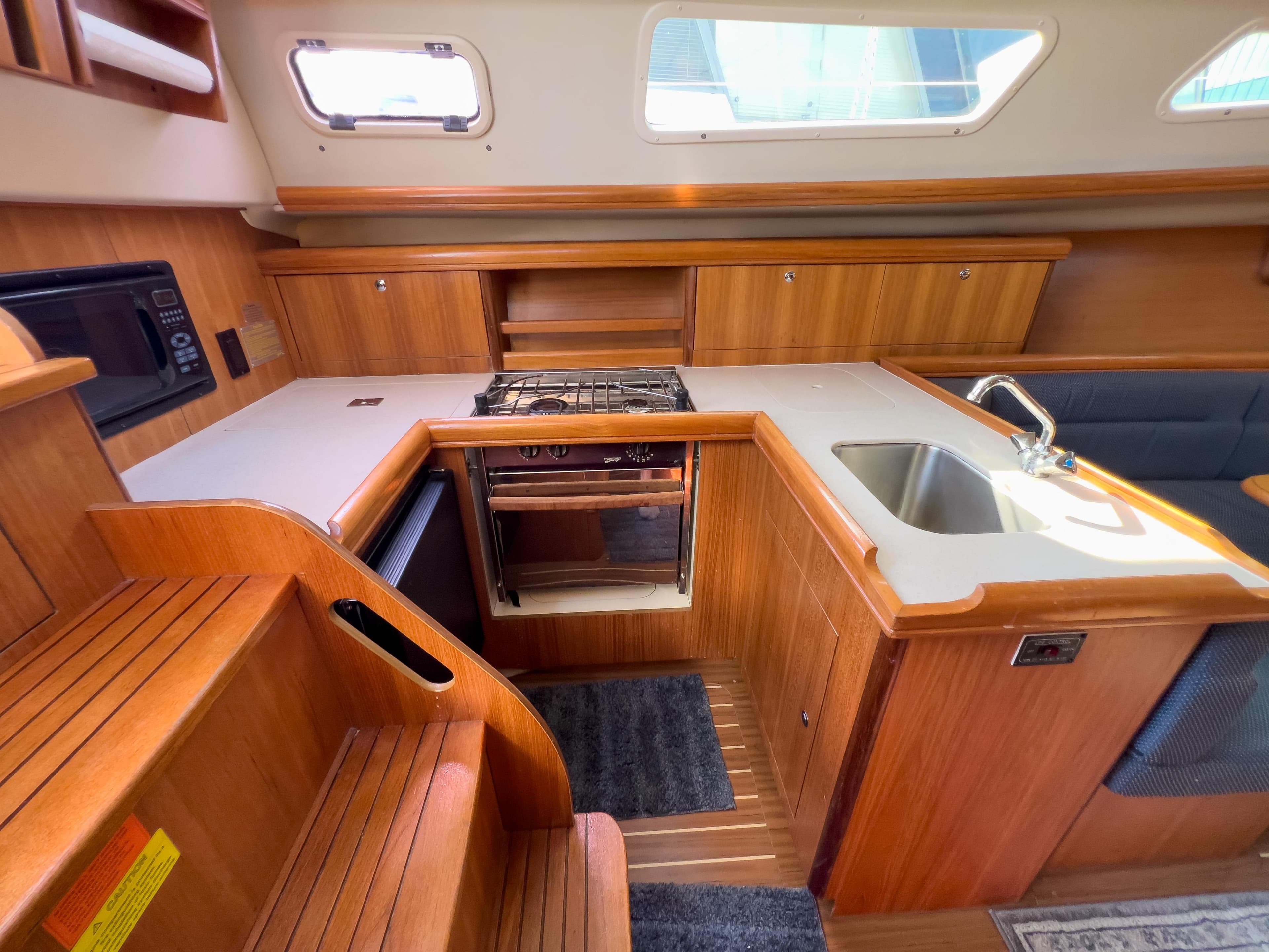 Interior of a 2006 Hunter 33 yacht with kitchen and wood paneling.