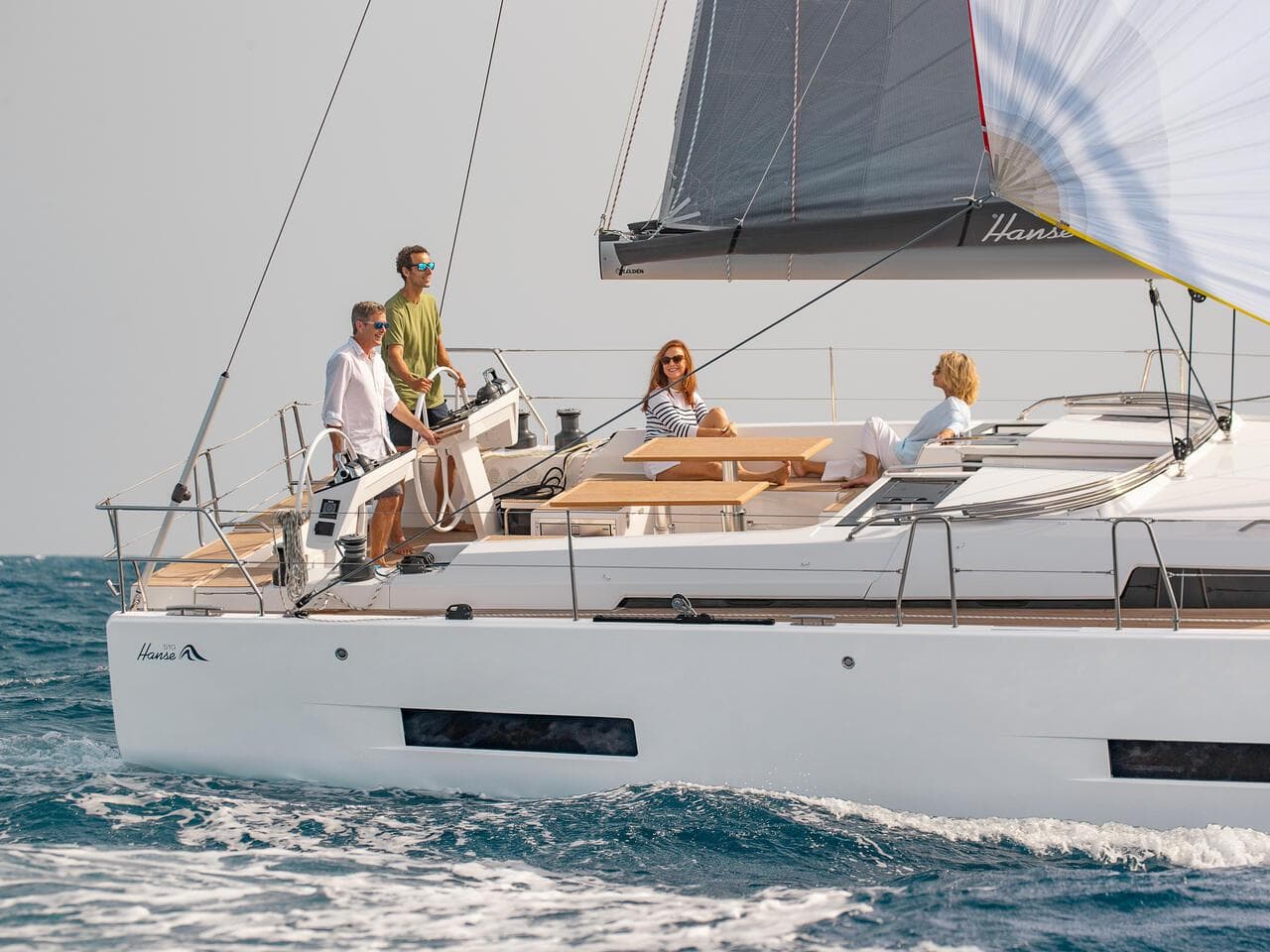 2025 Hanse 510 yacht sailing with passengers on deck in open water.
