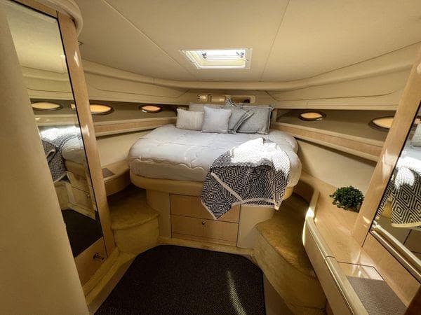 Luxurious bedroom interior of 2001 Sea Ray 460 Sundancer yacht with cozy bed and skylight.