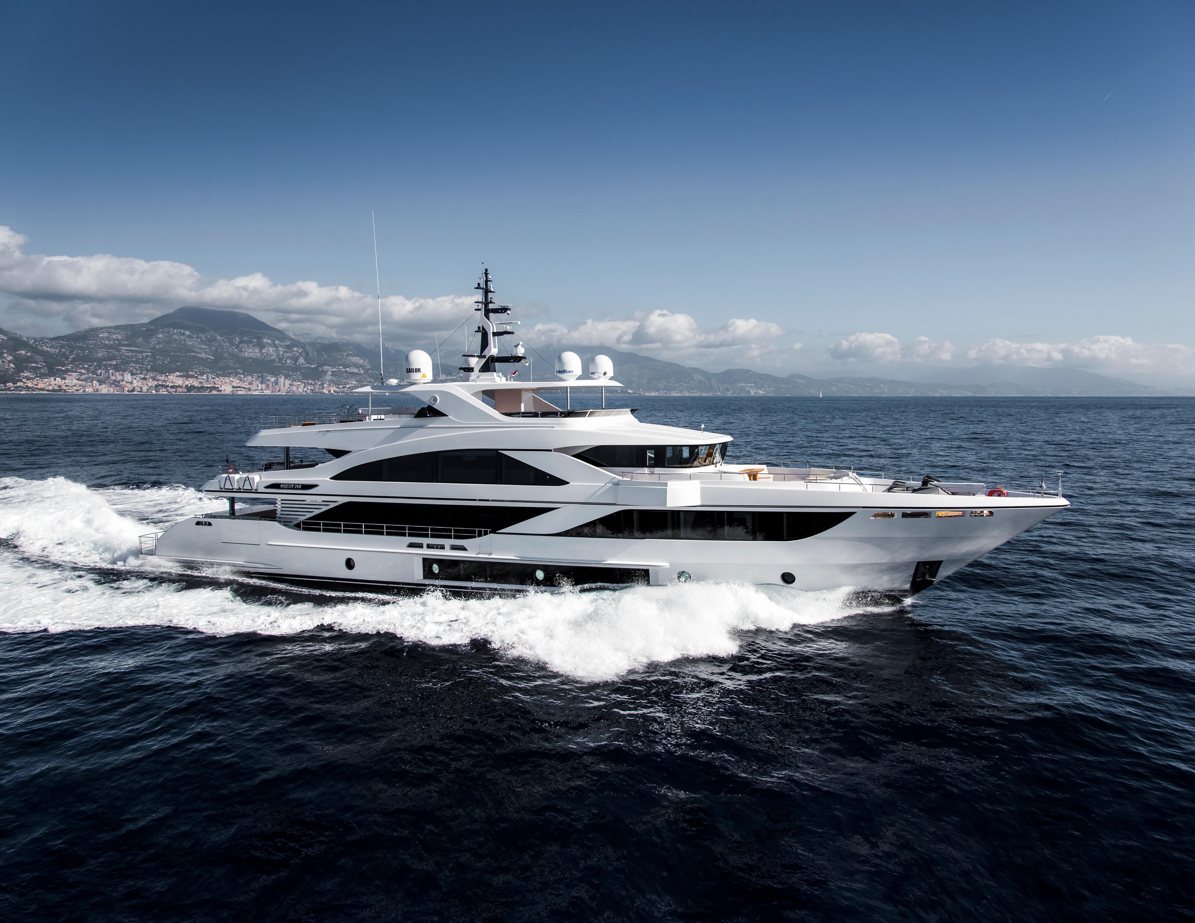 Luxurious 2025 Majesty 140 yacht cruising on open sea under clear blue sky.